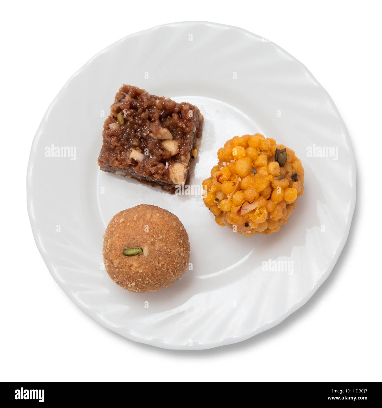 Indische Süßigkeiten auf einem Teller isoliert auf weiß Stockfoto