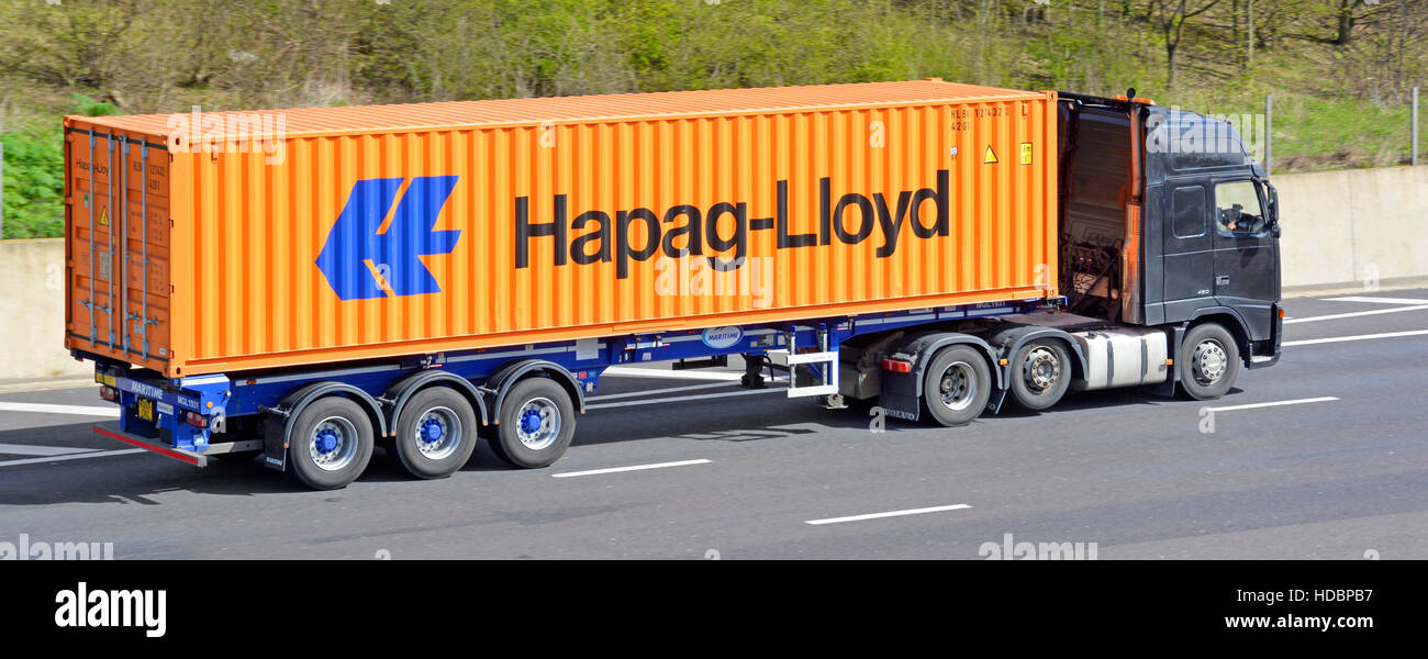 Transport von Hapag Lloyd in voller Länge Transportbehälter transportiert auf bewegliche Anhänger mit unmarkierten LKW LKW auf English UK Autobahn Logistik Stockfoto