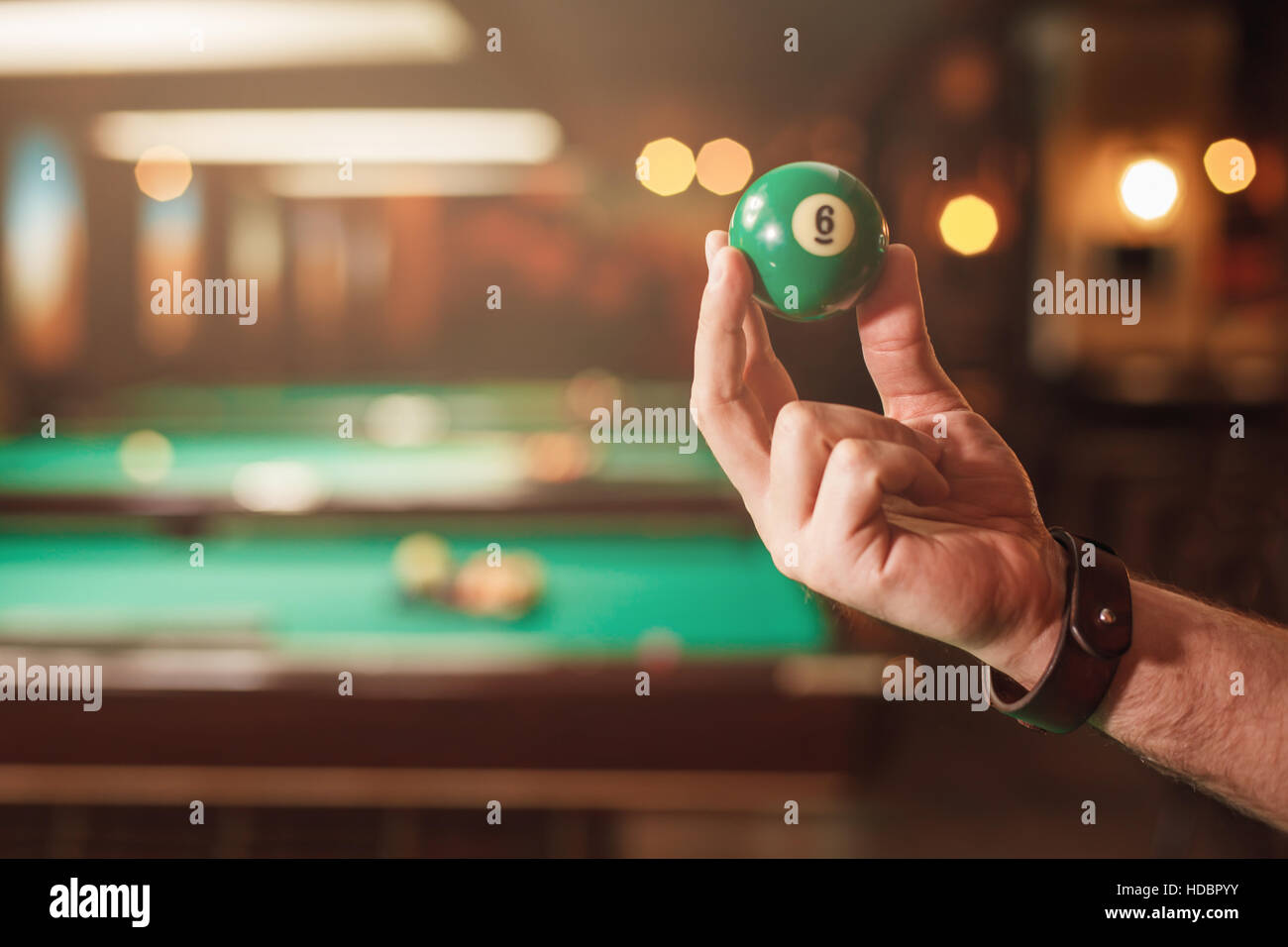 Männliche Hand zeigt eine Billard-Kugel-Nummer acht. Stockfoto