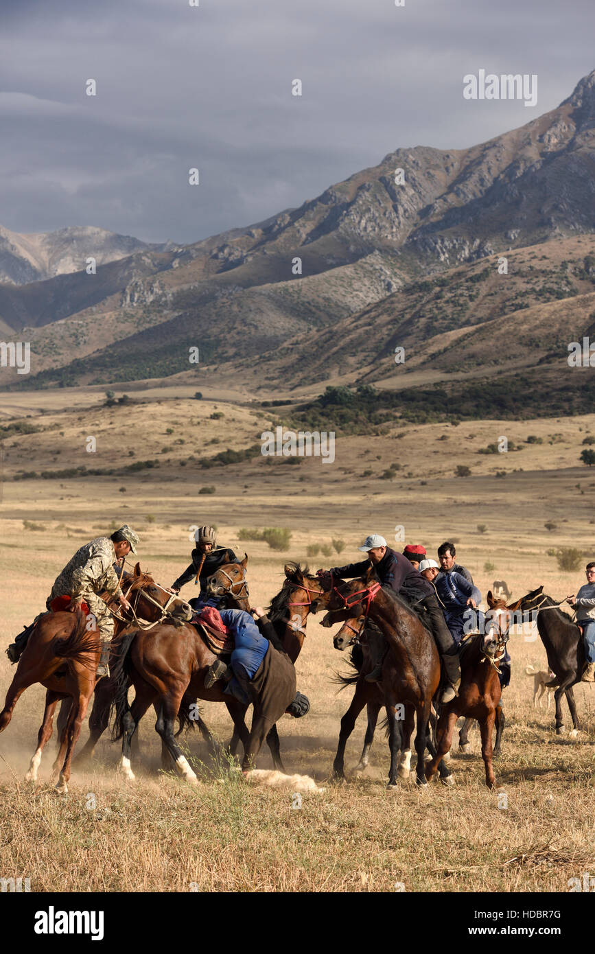 Reiter auf Pferd Ziege Karkasse im Spiel der Kokpar Tudabarai in Aksu Zhabagly Kasachstan abholen reichend Stockfoto