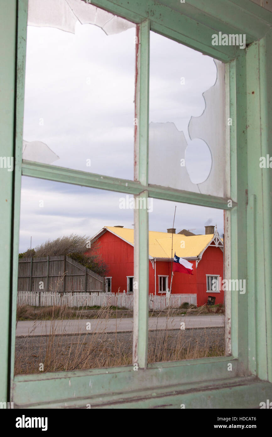 Altes rotes Gebäude, das durch ein kaputtes Fenster in der Estancia San Gregorio in Patagonischem Chile gesehen wurde Stockfoto