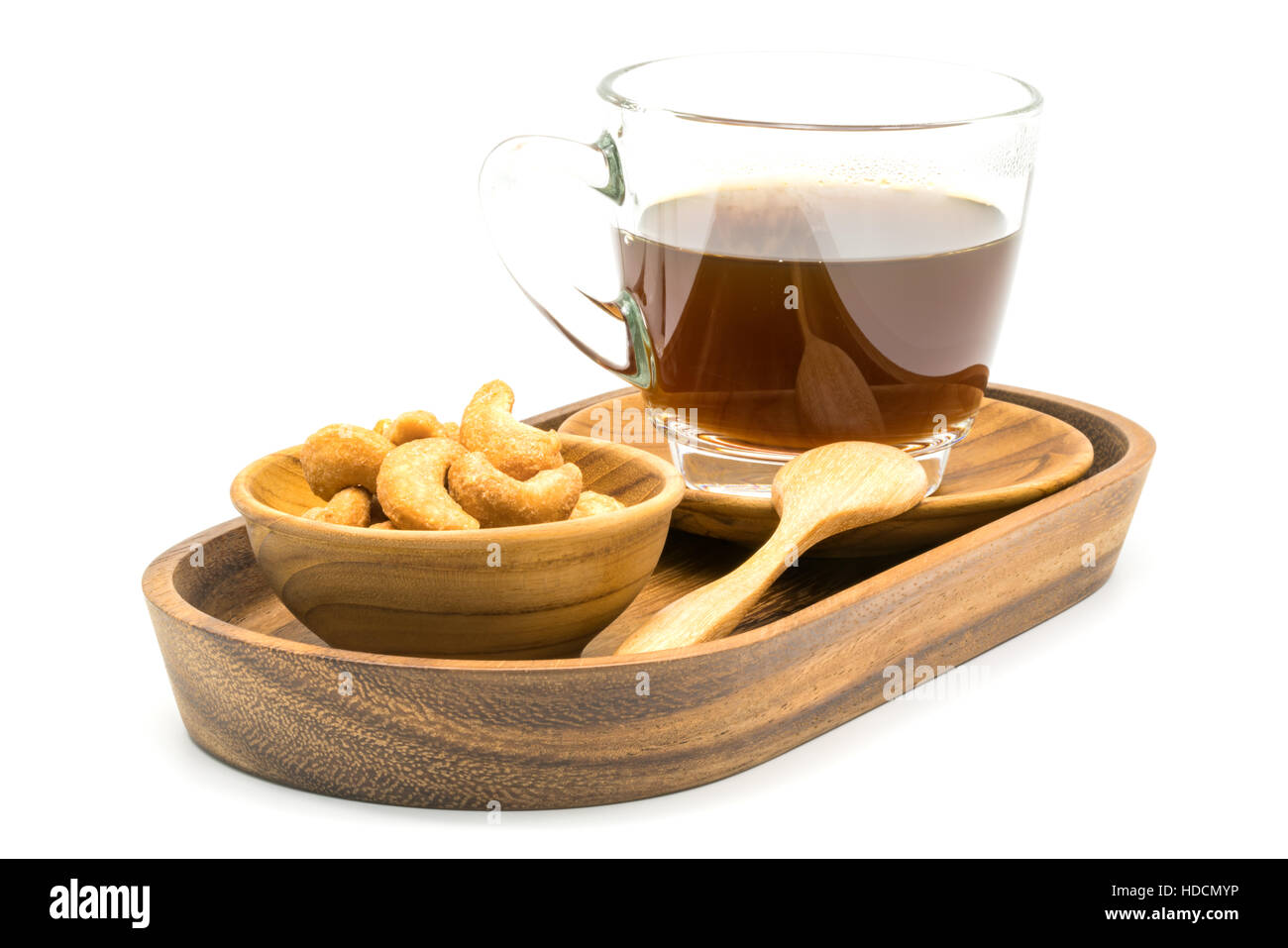 Salzige Cashew-Nüssen und eine Tasse schwarzen Kaffee in einer Schale auf weißem Hintergrund Stockfoto