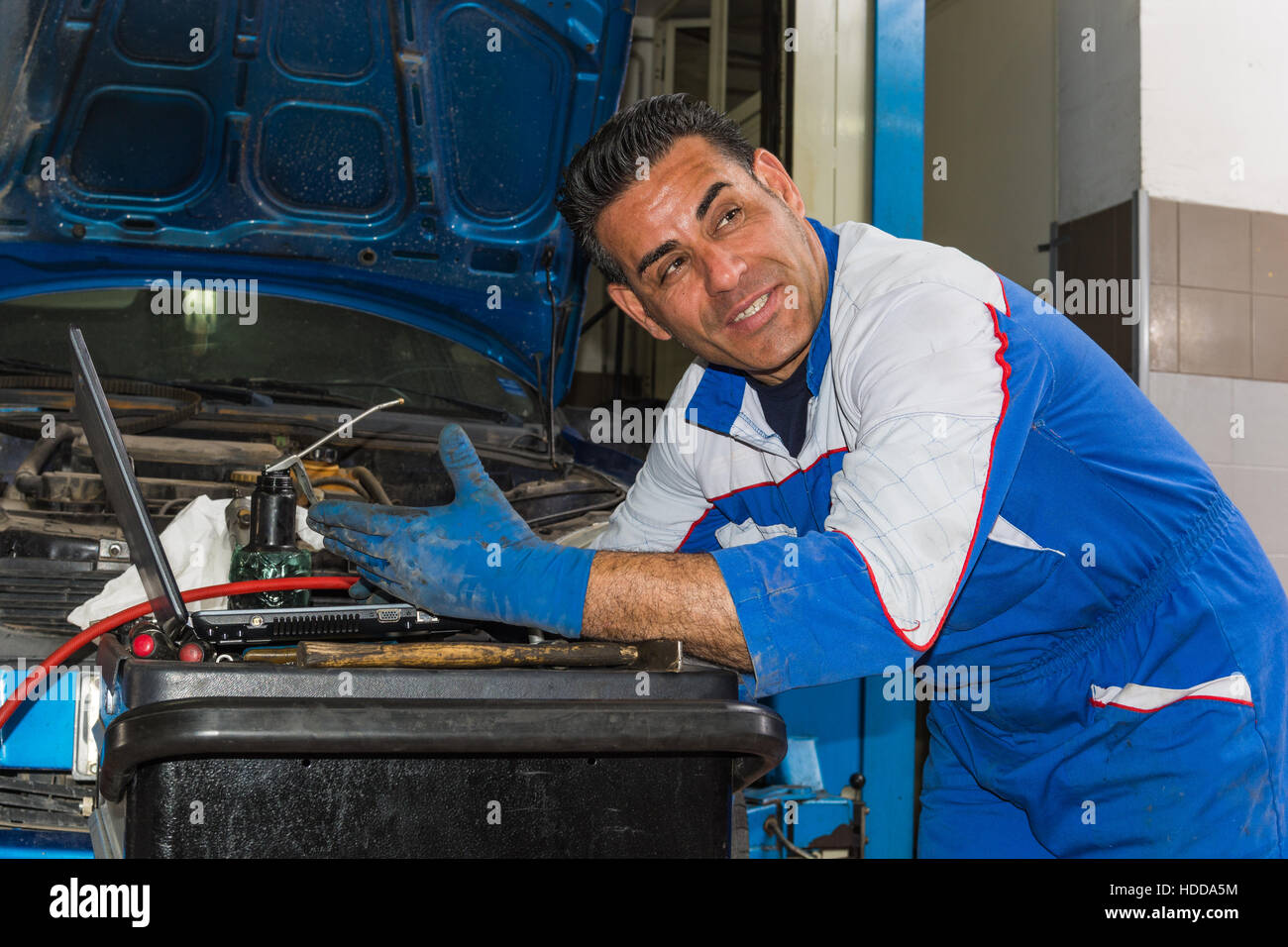 Kfz-Mechaniker Befestigung eines Motors in seiner Garage. Textfreiraum. Stockfoto