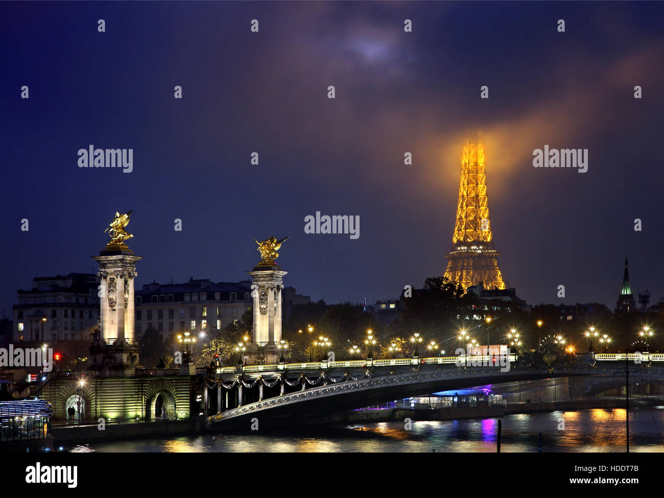 Die Alexandre III Brücke über Seineufer. Im Hintergrund der Eiffel Turm "piercing" die Wolken. Paris, Frankreich. Stockfoto