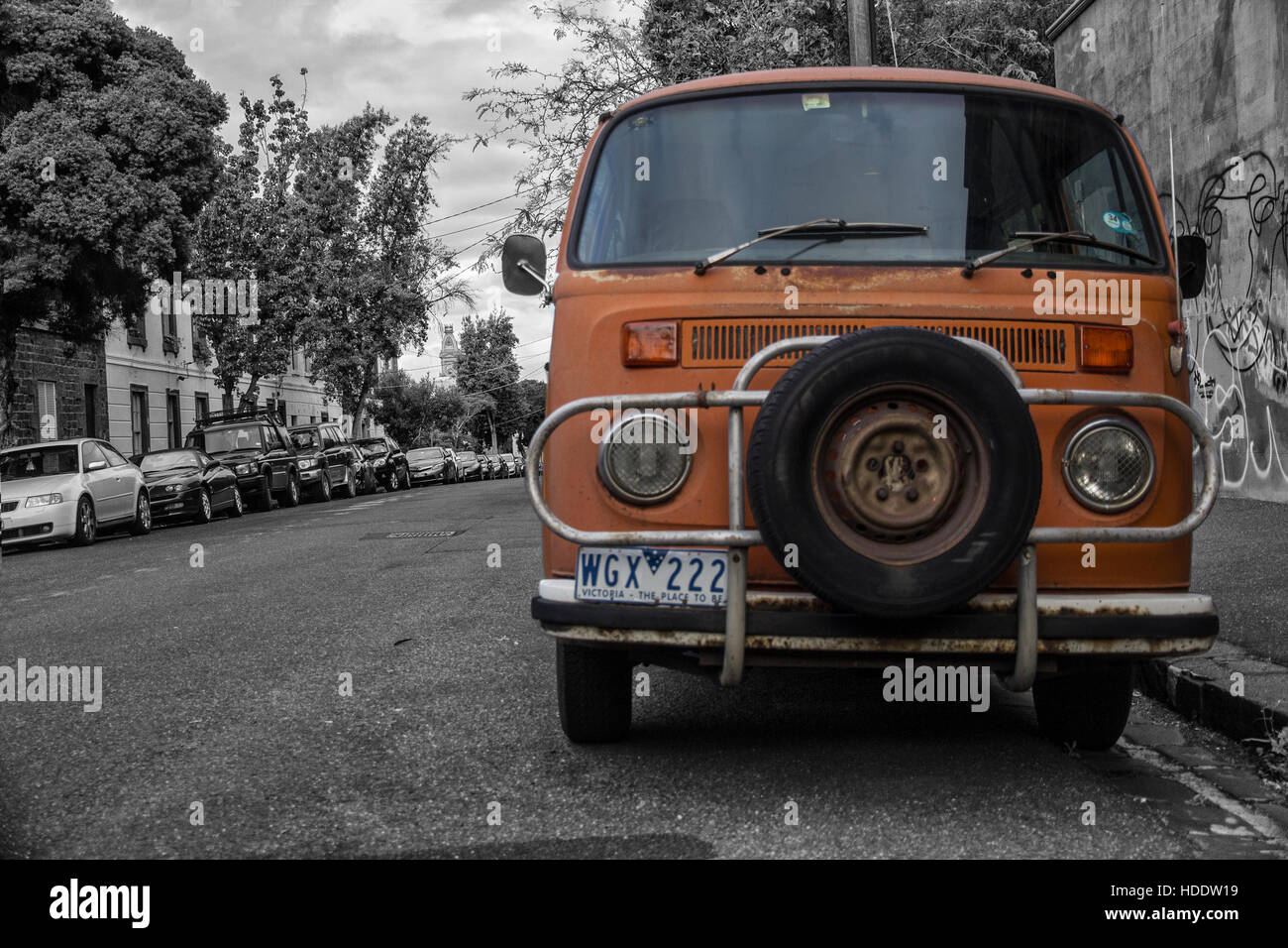 Alten VW-Bus bereit für Auslösung, den Kontrast zwischen der Stadt in schwarz / weiß und Orange die van inspirieren für neue Abenteuer Stockfoto