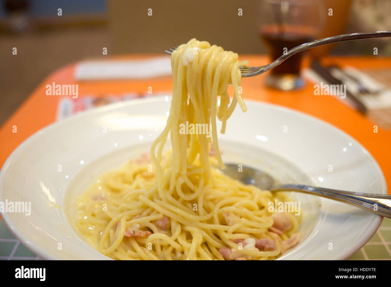 Spaghetti Carbonara auf die weiße Platte rollte auf die Gabel mit unscharfen Hintergrund Stockfoto