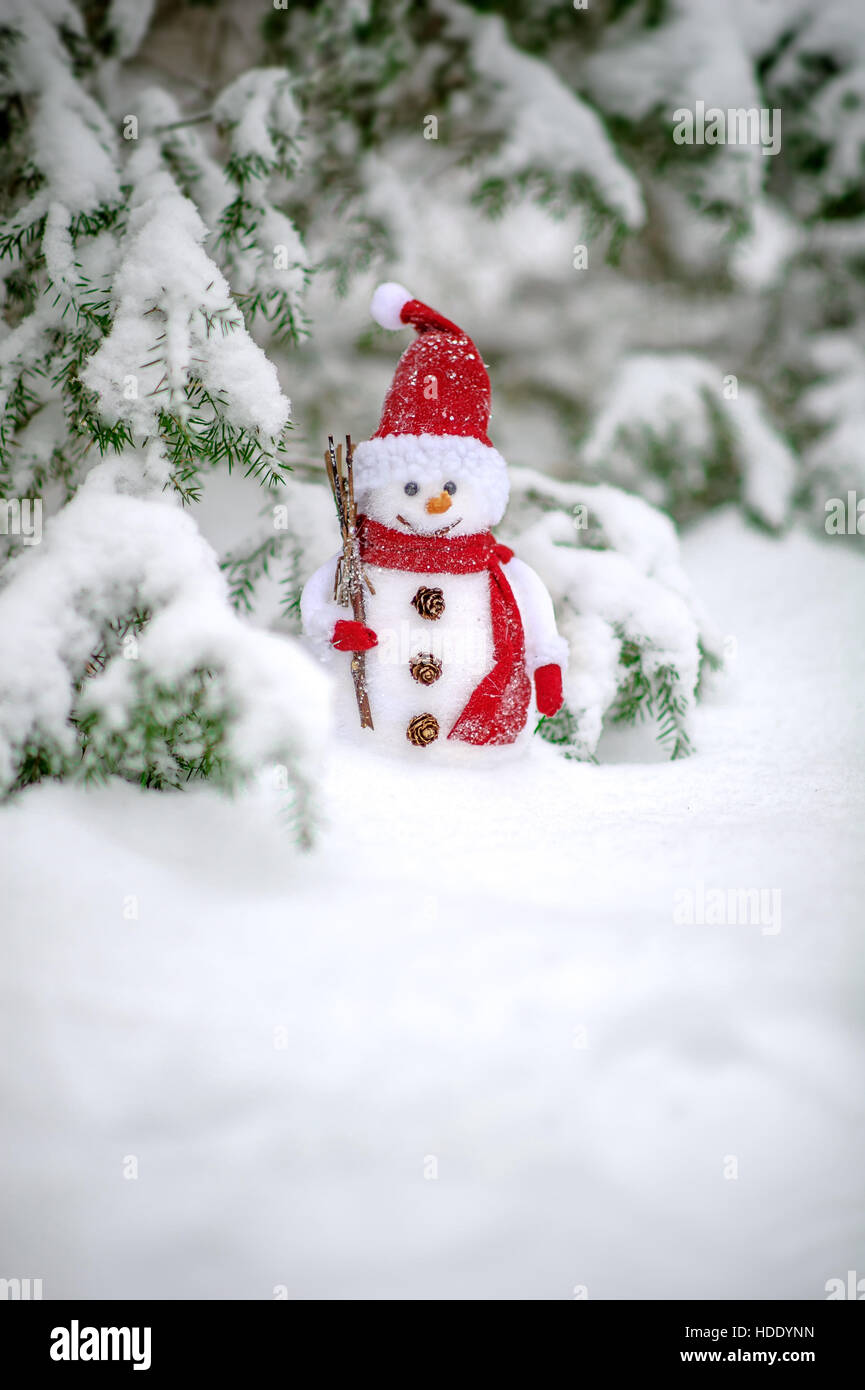 Weihnachtsspielzeug des Schneemanns im Schnee bedeckt Wald der in Stockfoto