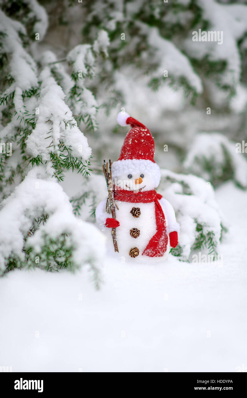 Weihnachtsspielzeug des Schneemanns im Schnee bedeckt Wald Stockfoto