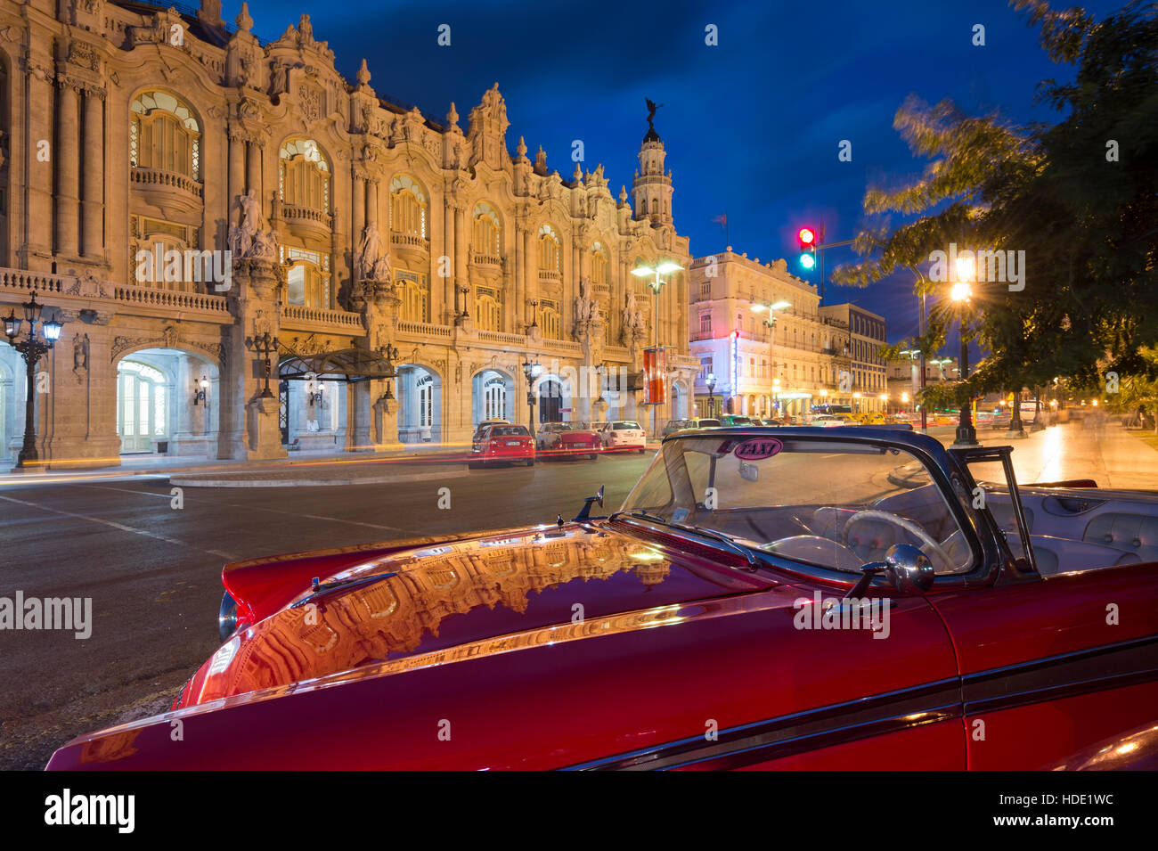 Das Gran Teatro De La Habana spiegelt sich auf 50er Jahre amerikanische Taxi am Paseo de Marti in der Nacht, Havanna Stockfoto