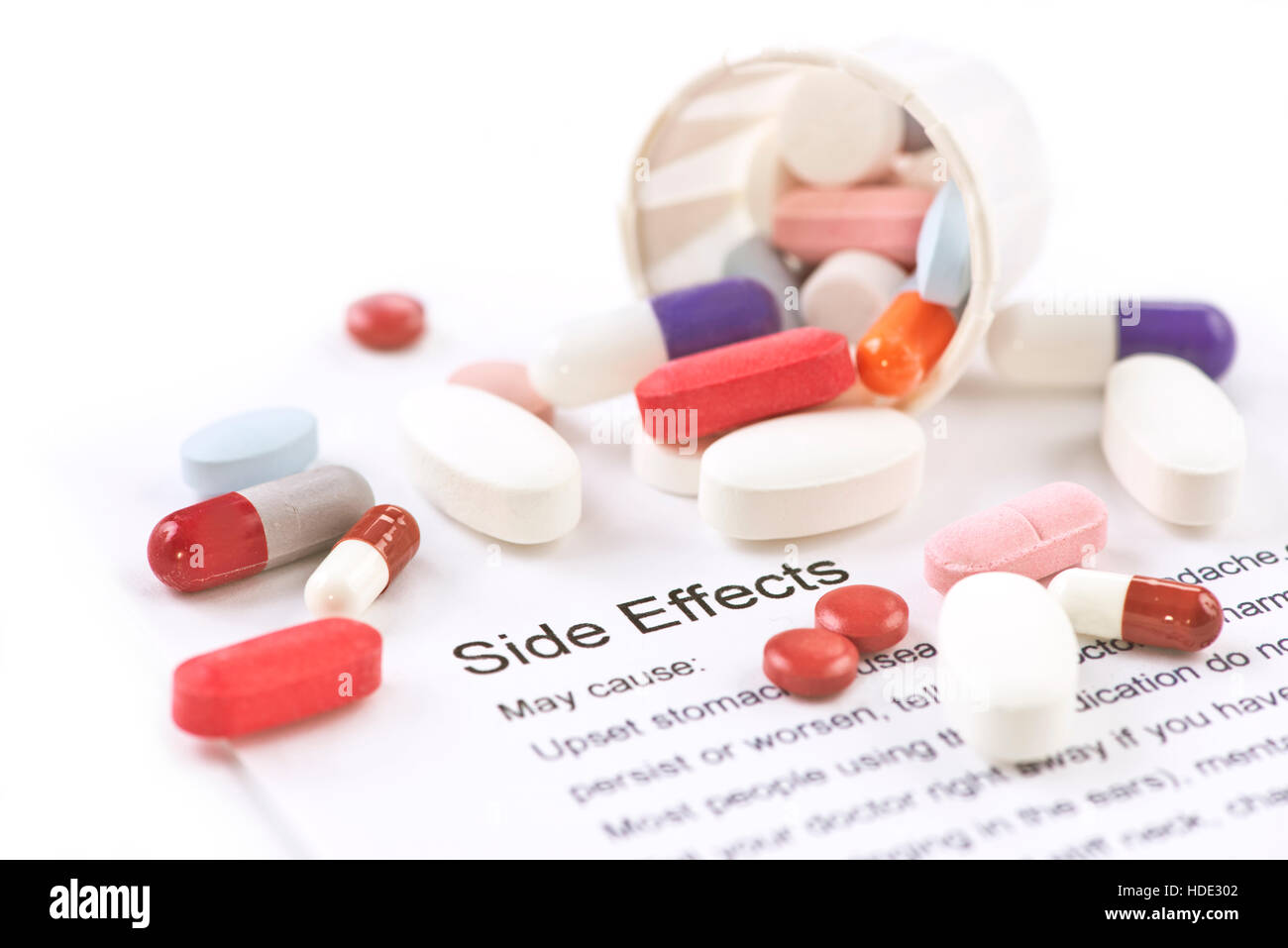 Verschiedene Pillen und Kapseln mit Nebenwirkungen-Informationsblatt. Stockfoto