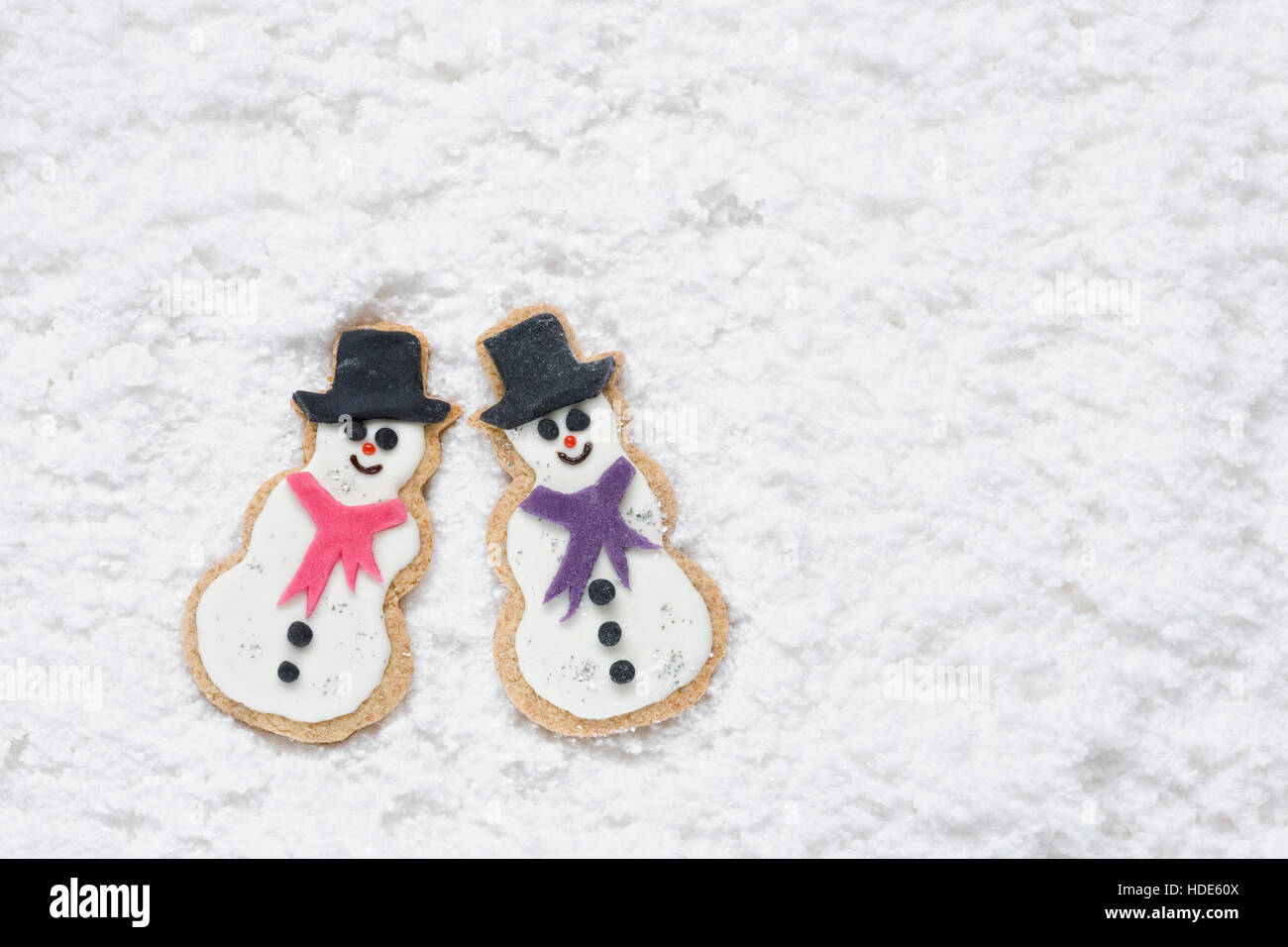 Zwei hausgemachte Schneemänner Kekse auf einem verschneiten Hintergrund. Stockfoto