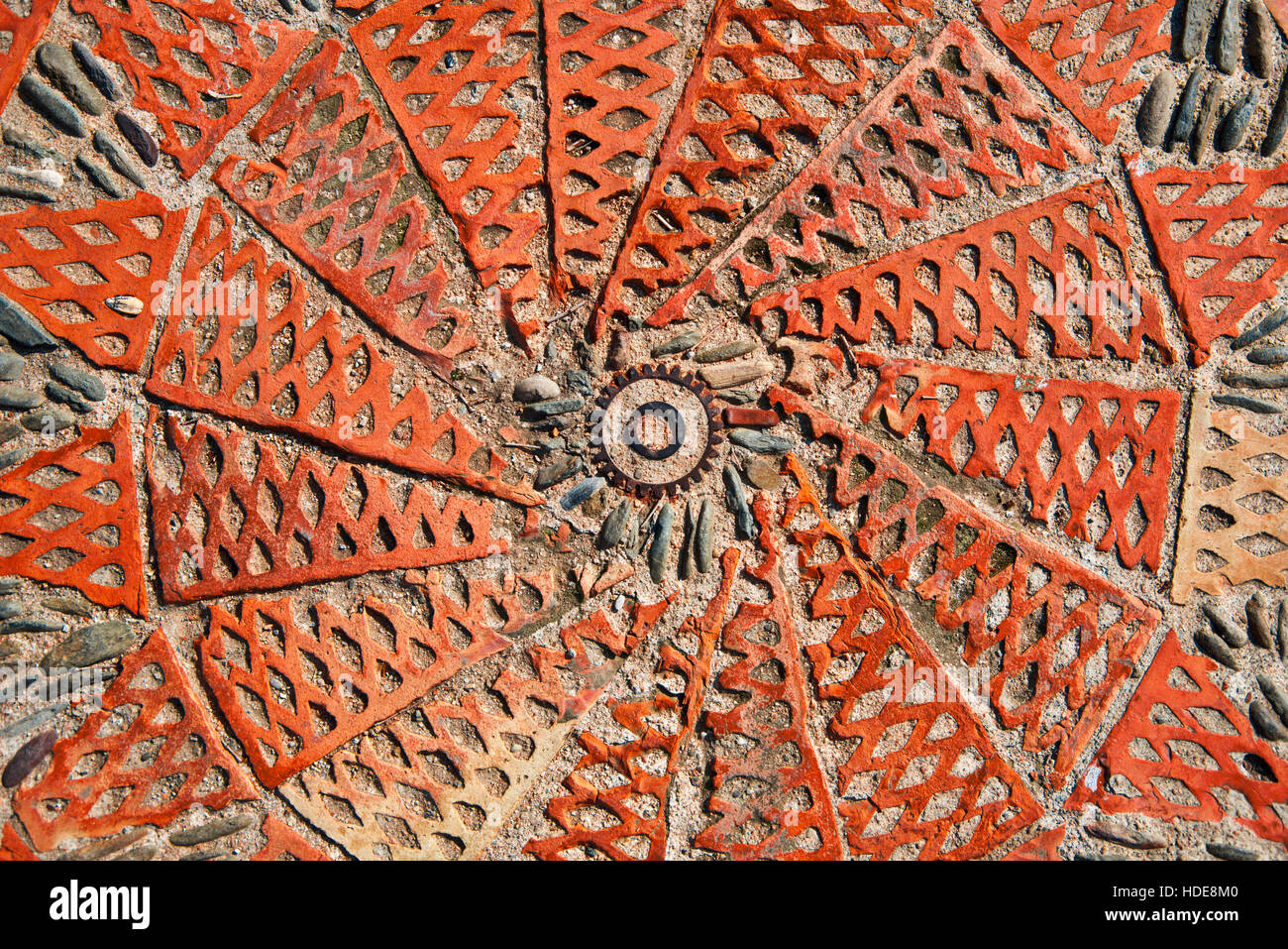 Kunstwerke aus Stein, rostige Zahnrad auf dem Boden. Kunst-Hintergrund Stockfoto