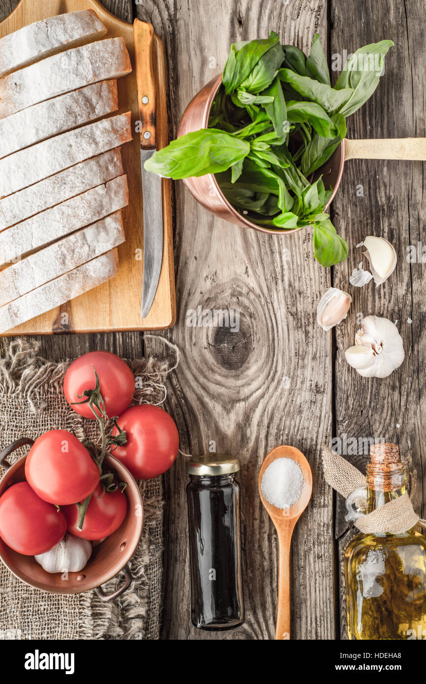 Zutaten für Bruschetta auf der hölzernen Tischplatte anzeigen Stockfoto