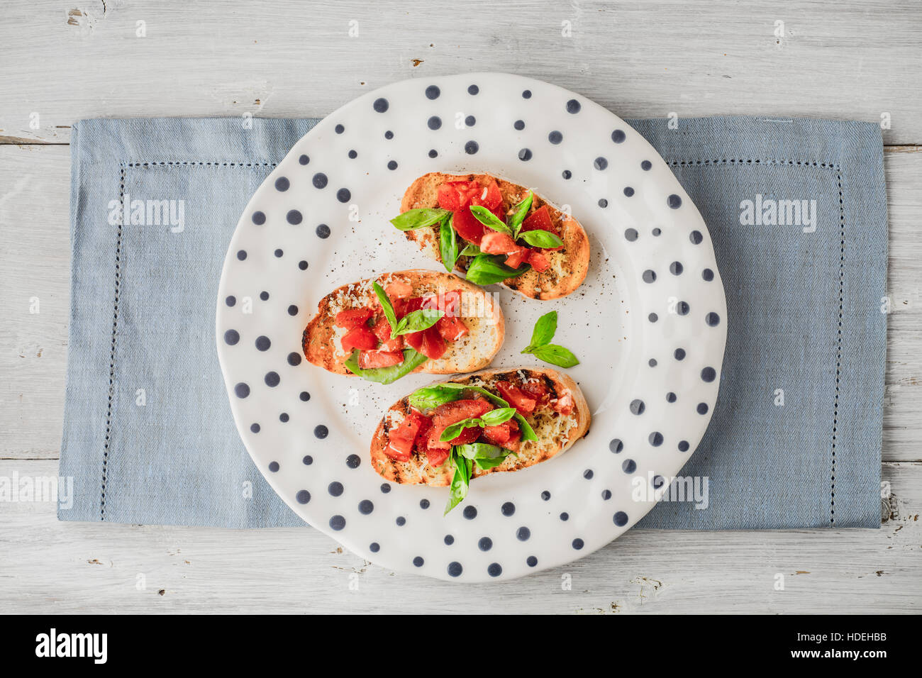 Bruschetta mit Tomaten und Basilikum in der Draufsicht Keramikplatte Stockfoto