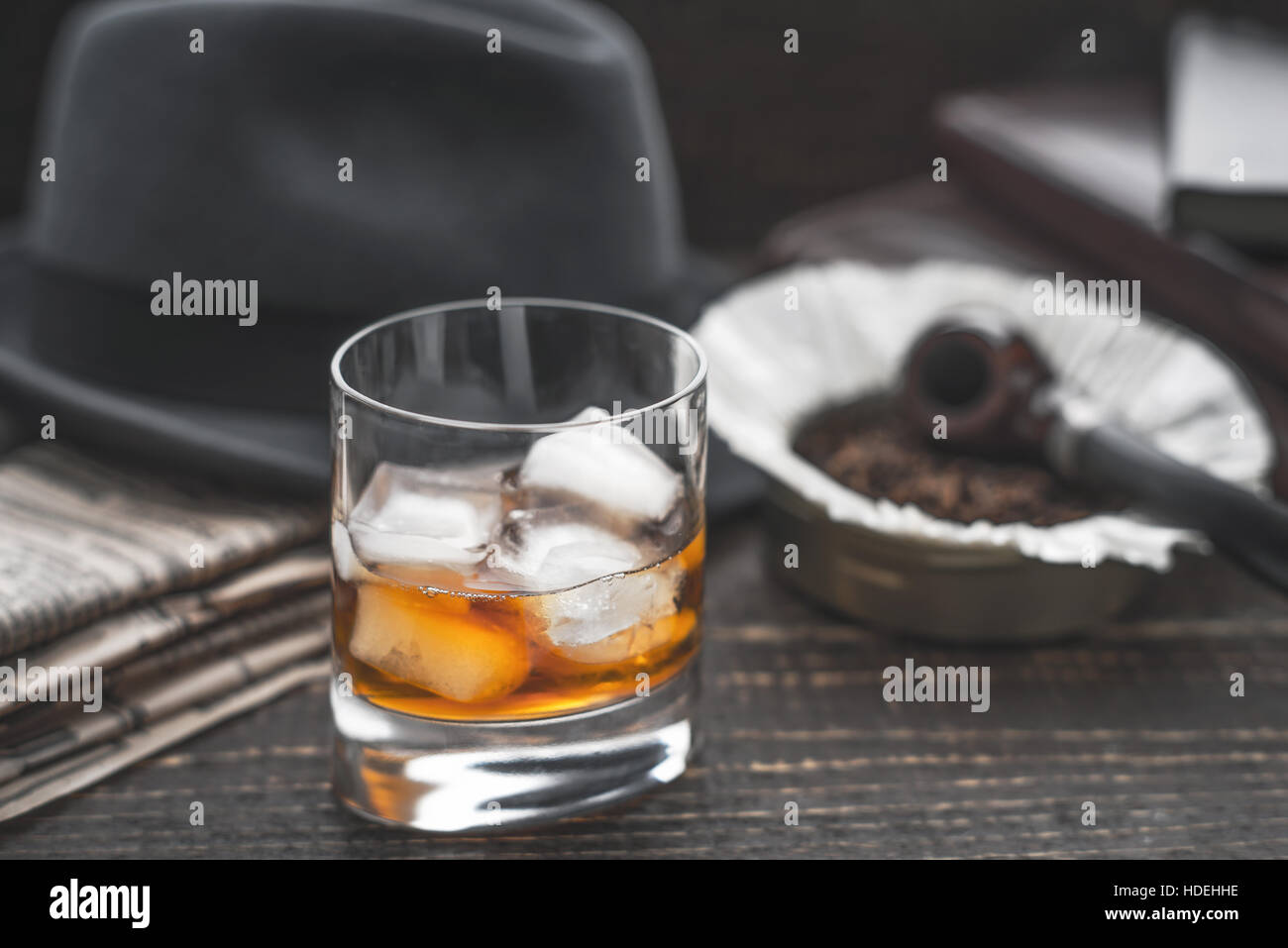 Whisky mit Eis, Rohr-Hut und horizontale Zeitung Stockfoto