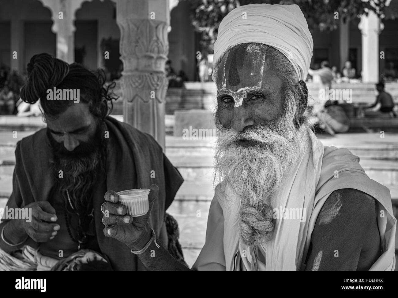 Ein Sadhu, hinduistischen heiligen Mann, gekleidet in traditioneller Tracht genießt eine Pause und Tasse Tee während der Pilgerfahrt zu den Heiligen Stadt Pushkar Stockfoto