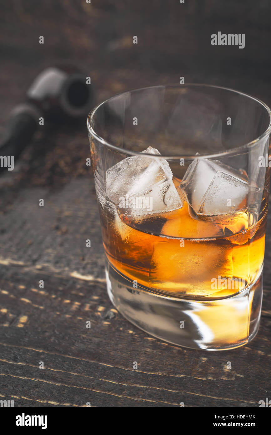 Whisky mit Eis und unscharfen Rohr vertikal Stockfoto
