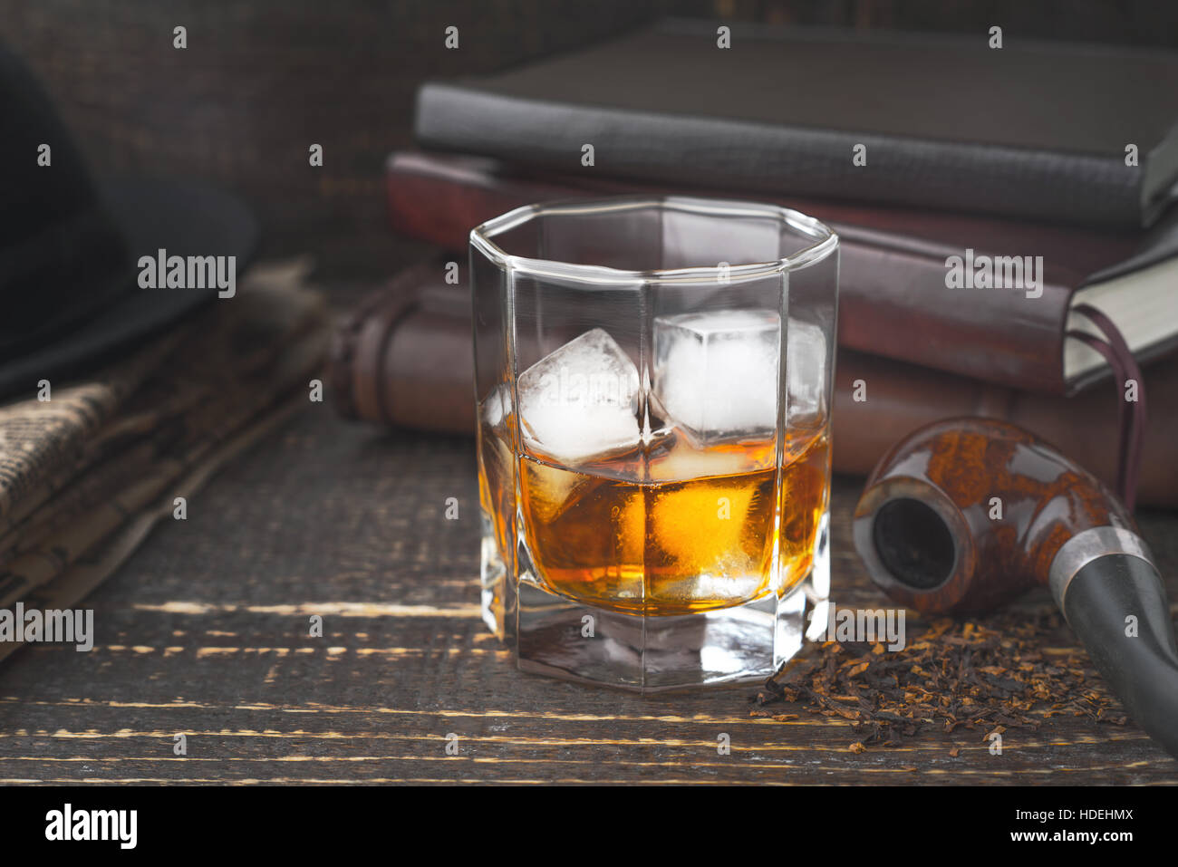 Whisky mit Rohr, Hut und Zeitung Stockfoto