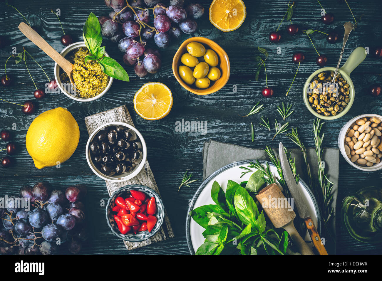 Konzept der mediterranen Küche. Verschiedene Früchte, Kräuter und Vorspeisen auf der hölzernen Tischplatte anzeigen Stockfoto