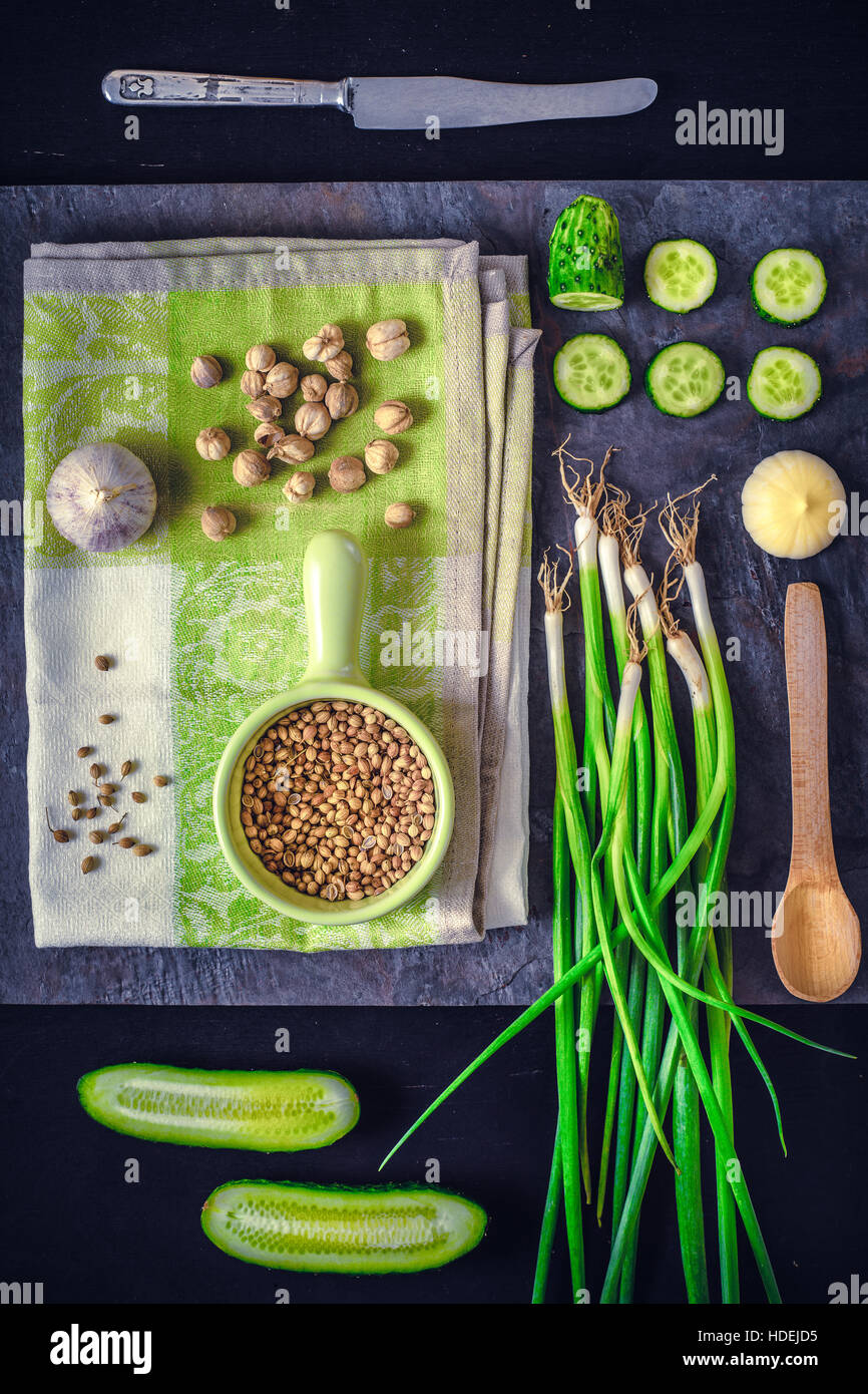 Grünes Gemüse mit Gewürzen auf dem dunklen Stein Hintergrund vertikale Stockfoto
