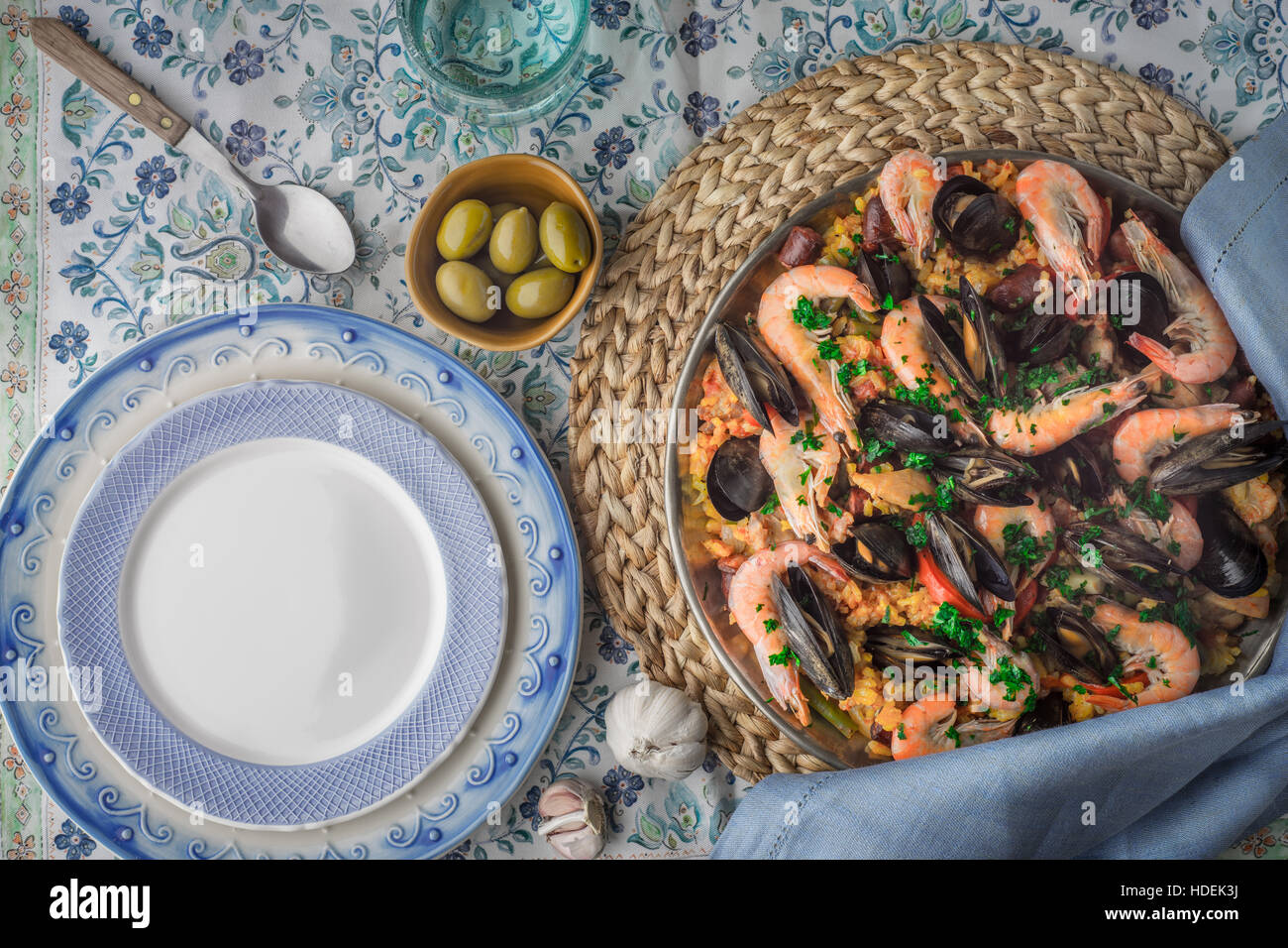 Paella auf der Metallplatte auf die schöne Serviette mit Geschirr-Draufsicht Stockfoto