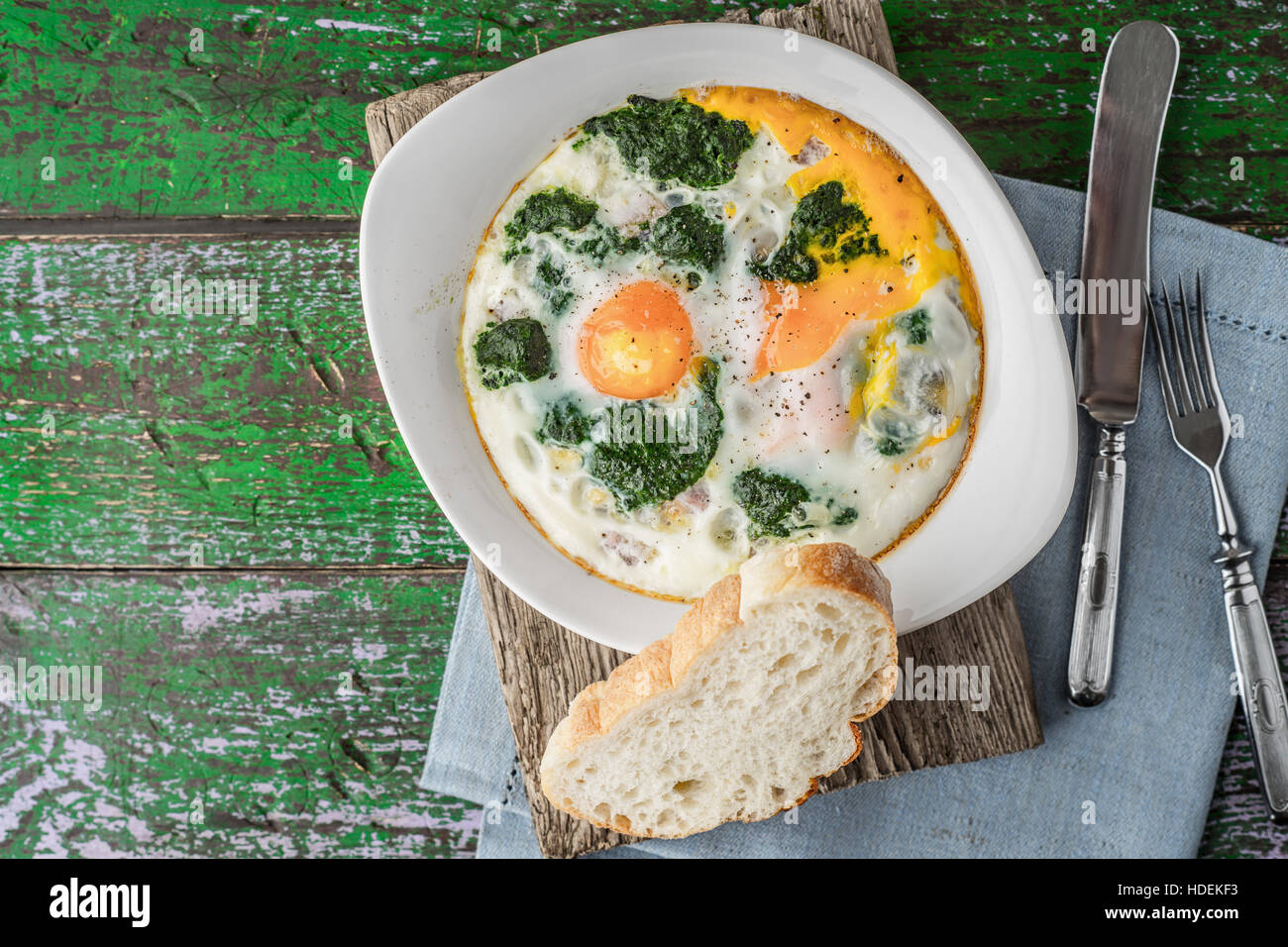 Florentiner Eiern mit pürierten Spinat auf dem Holztisch horizontale Stockfoto