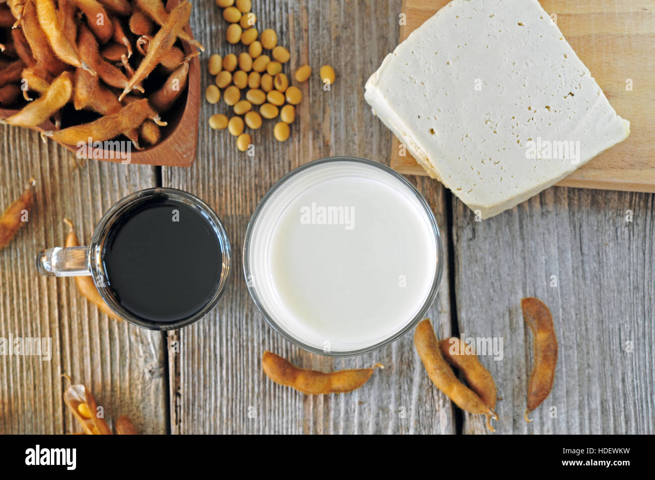 Glas Sojamilch, Soße und Tofu auf einem Holztisch, Ansicht von oben Stockfoto