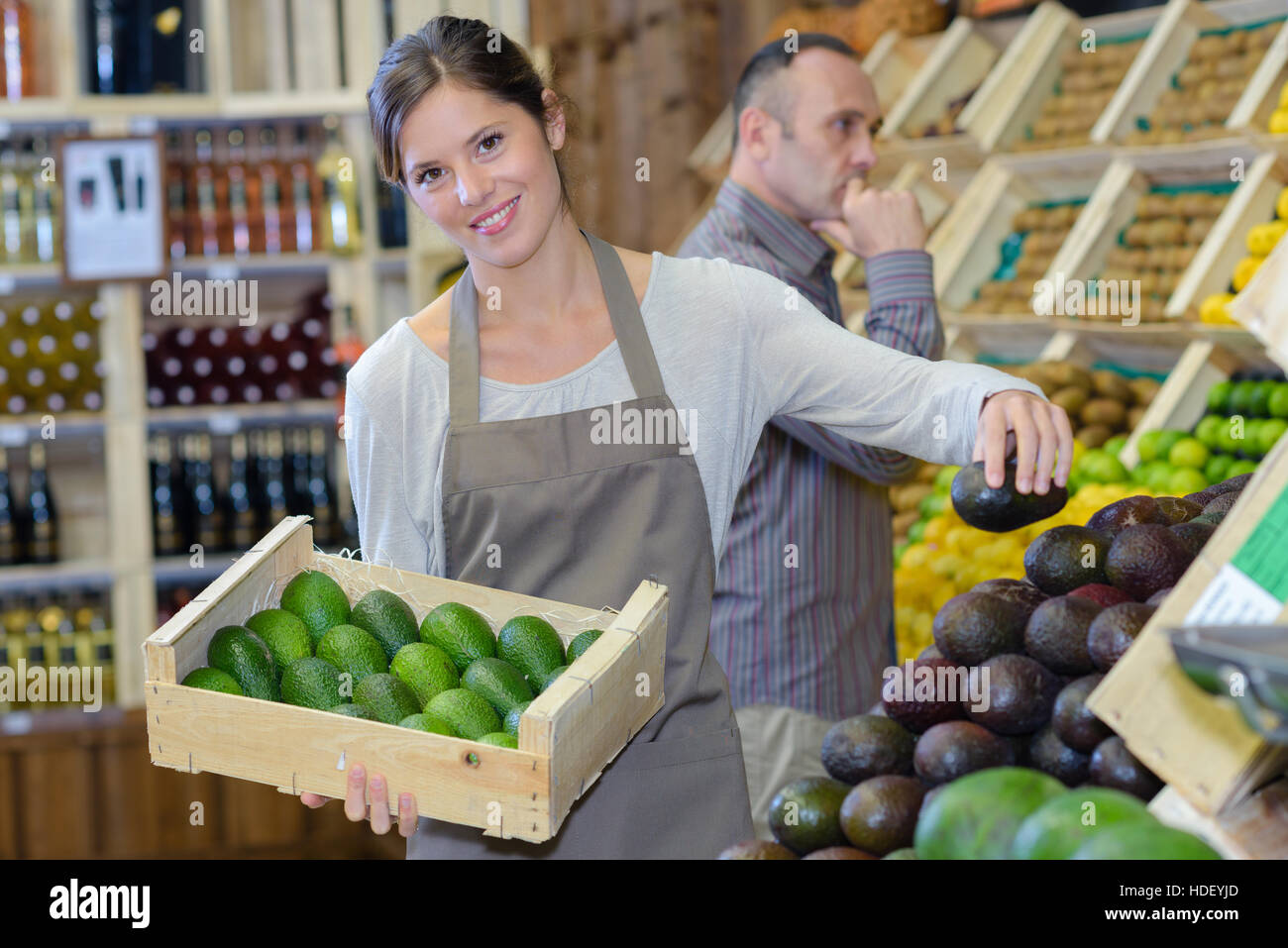 Frau Stapeln Avocados in Obst-und Gemüsehändler Stockfoto