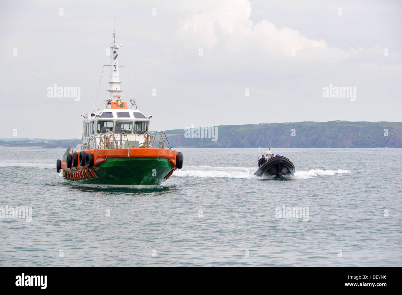 Lotsenboot und Polizei Rippe Anfahren auf einem ruhigen Meer. Stockfoto