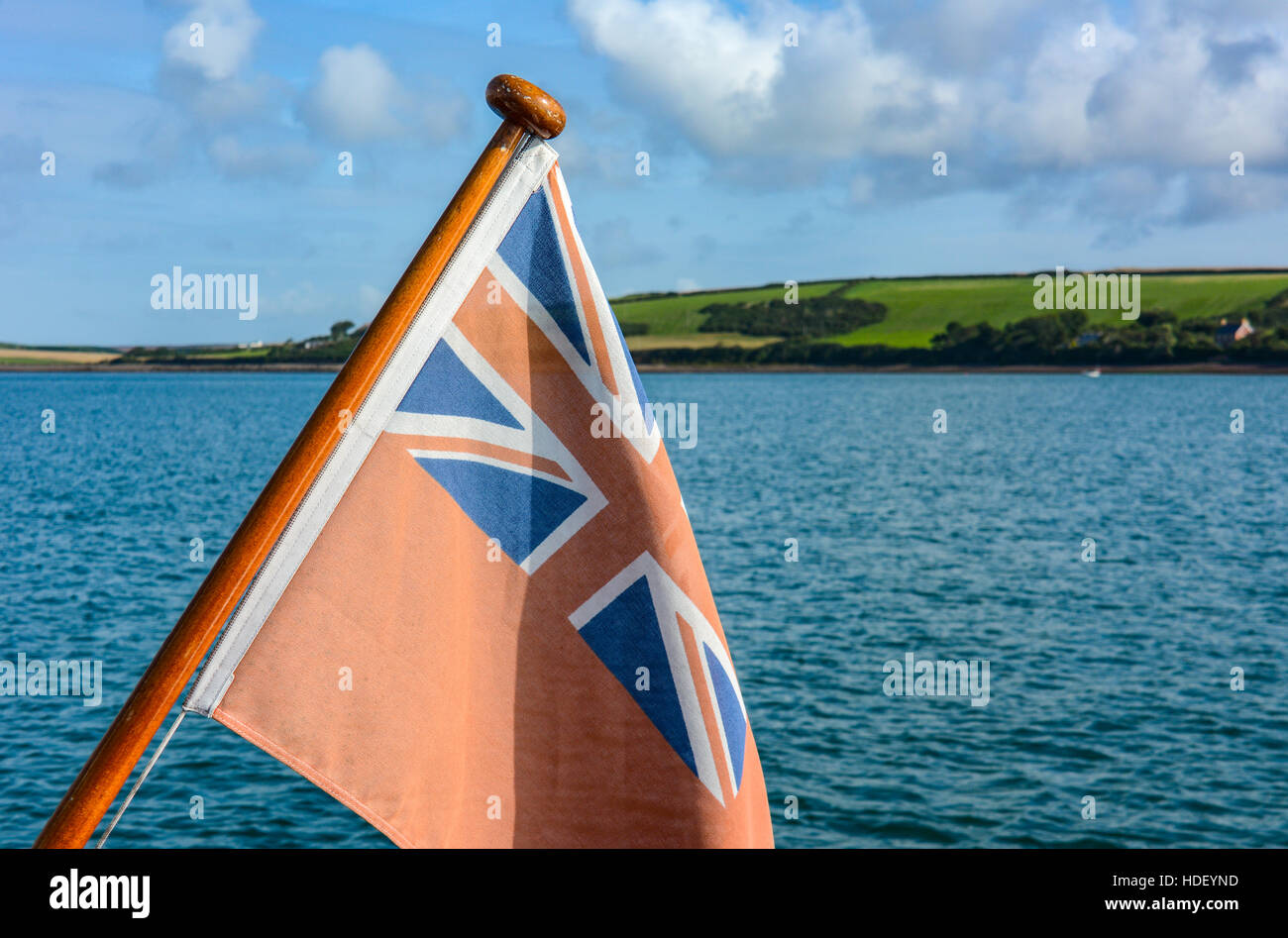 Red Ensign im Sommer Sonne morgens vor der Azure wellige Meer und grüne Felder. Stockfoto