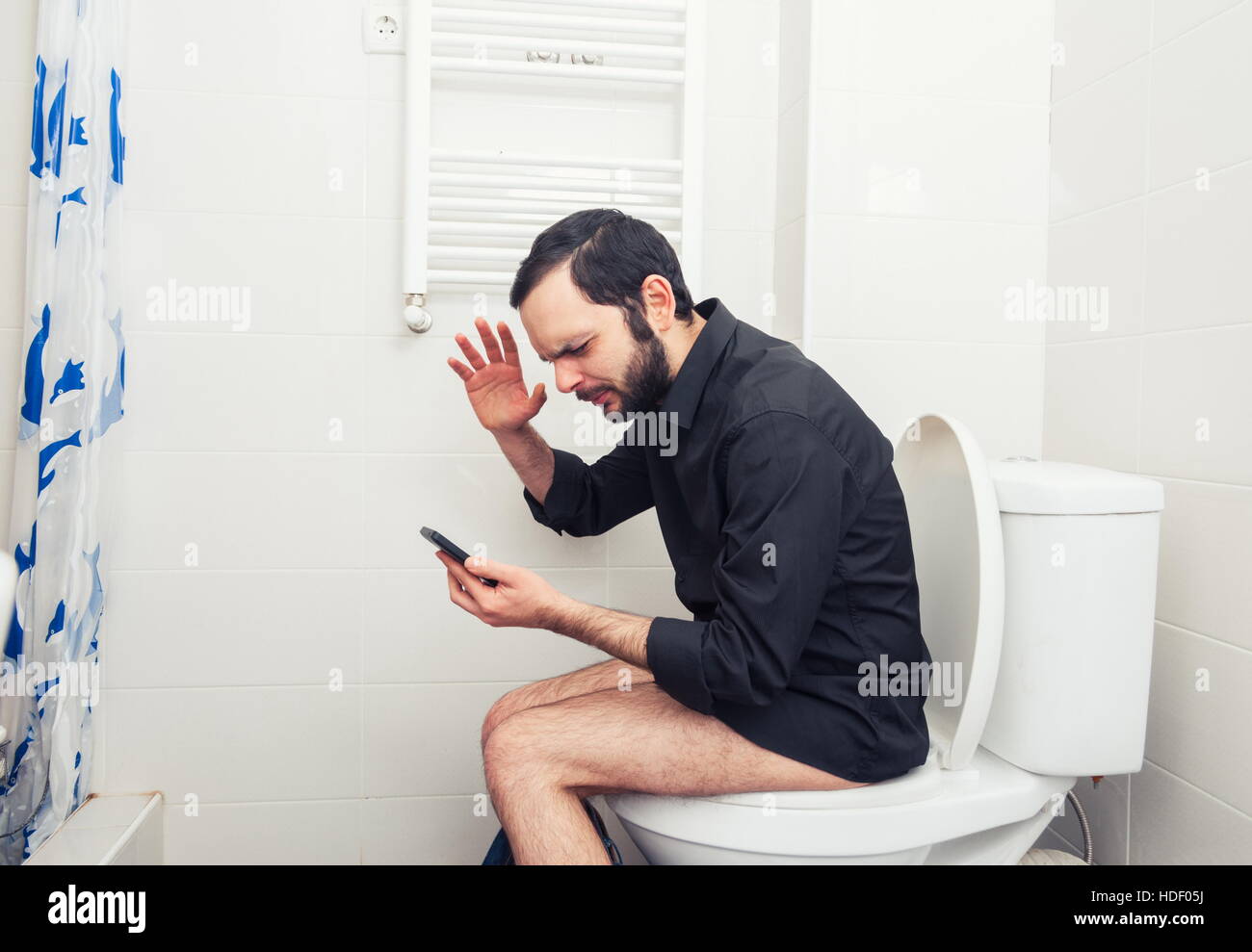 Mann in der Toilette sitzen und telefonieren Stockfotografie - Alamy