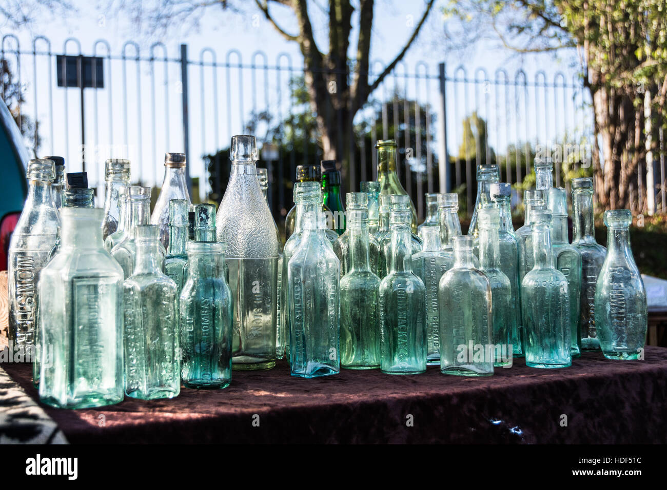 Eine Reihe von viktorianischen Glasflaschen auf einem Tisch auf einem Flohmarkt in London, England, UK Stockfoto