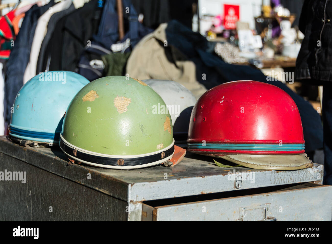 Mehrfarbige Motorradhelme und Nippes auf einem Flohmarkt in London, England, UK Stockfoto