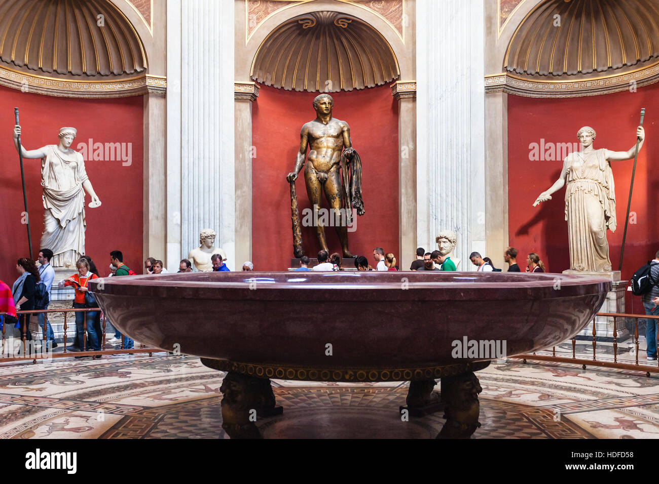 Vatikan, Italien - 2. November 2016: Touristen und römische Statuen, Herkules-Skulptur und Runde monolithischen Porphyr-Becken im runden Raum der Pio-Clementino Stockfoto