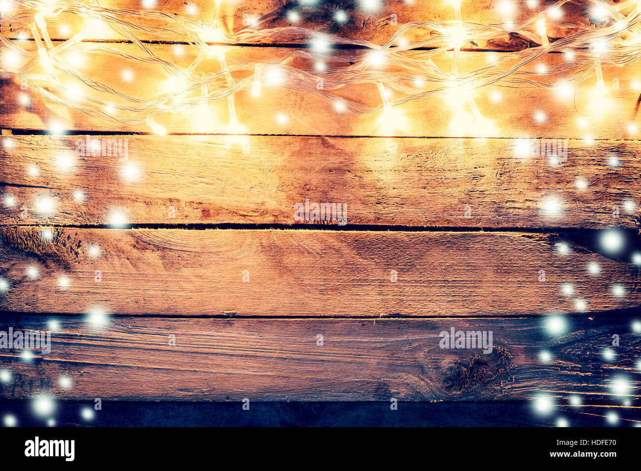 Weihnachtslicht und Schnee auf hölzernen Hintergrund mit Raum Stockfoto