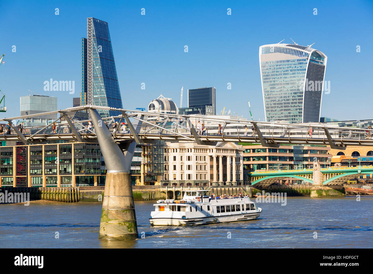 LONDON, UK, Touristen am Kiesstrand von Thames mit Millennium Bridge und Stadt skyline Stockfoto