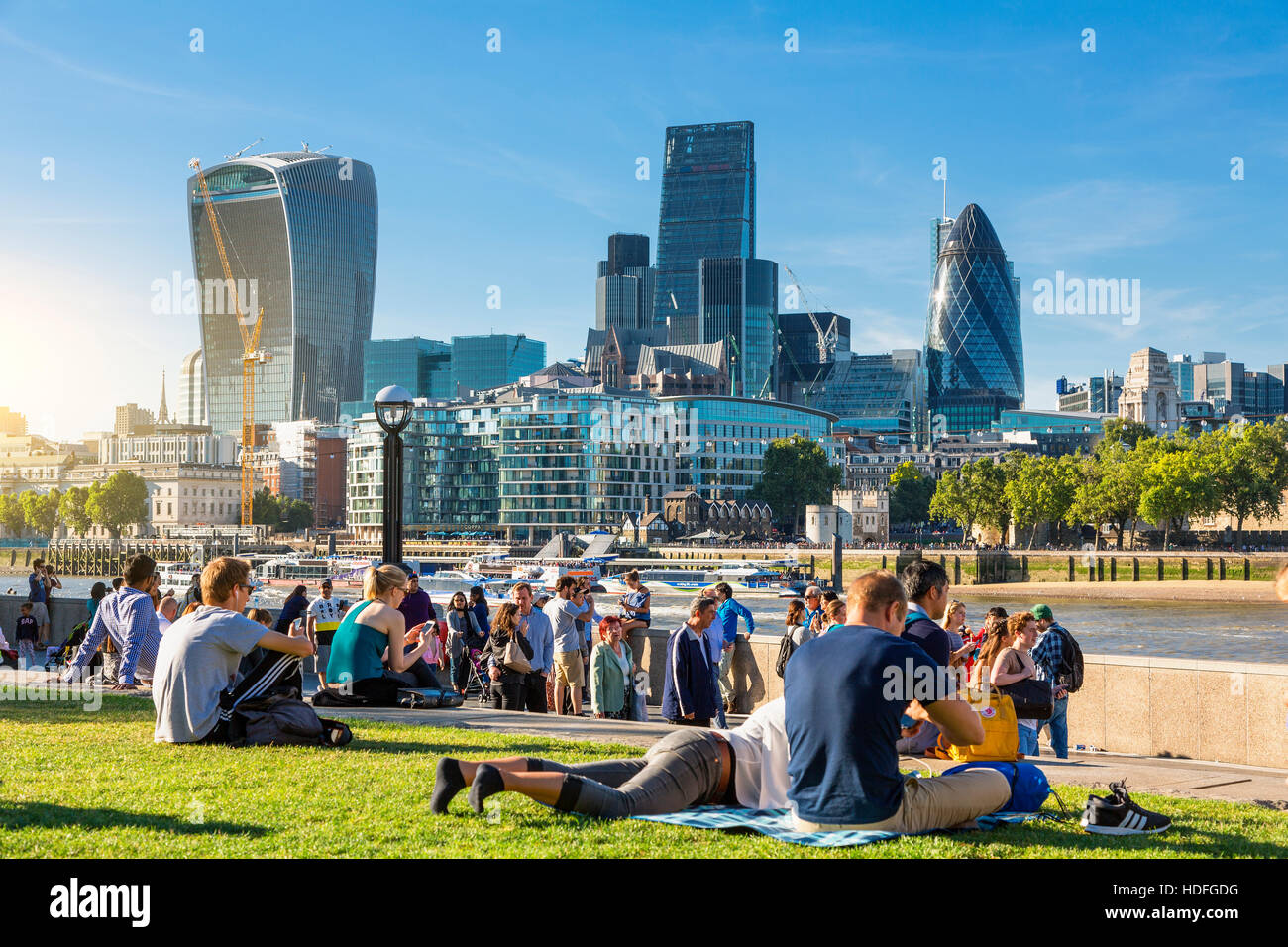 LONDON, der Königin Südufer Fuß London. Touristen genießen Sie Sonne und Schatten von Tower Bridge auf der Southbank der Themse Stockfoto