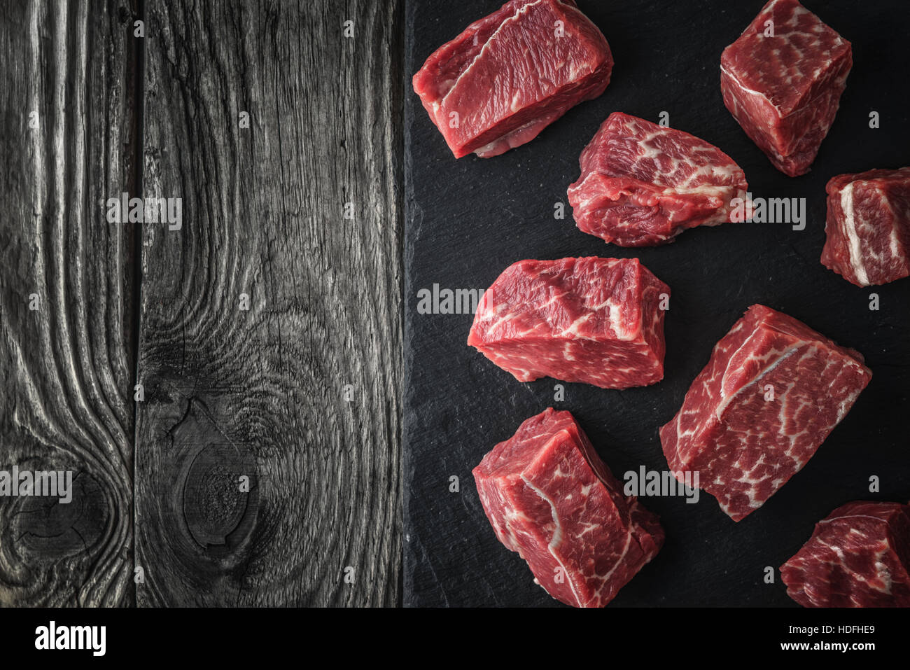 Roh Angus-Rindfleisch-Scheiben auf dem schwarzen Stein auf den Holztisch horizontale Stockfoto