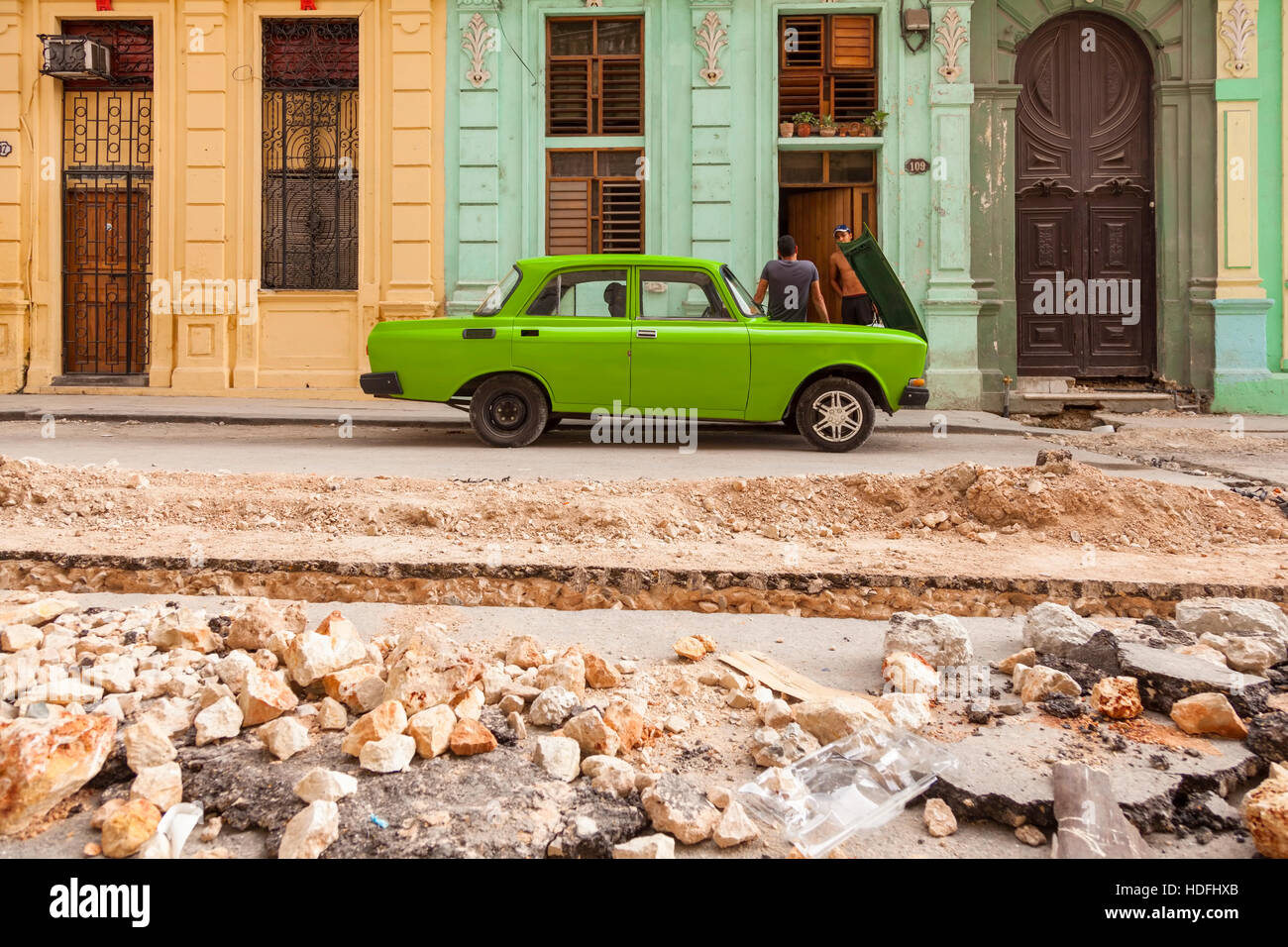 Eine Straße in Bau und einem lindgrünen Oldtimer in Zentral-Havanna, Kuba zerrissen. Stockfoto