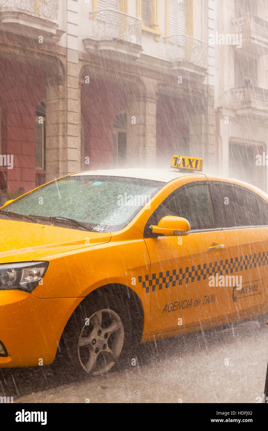 Ein (Agencia de Taxi) registriert Taxi Cab im strömenden Regen in Alt-Havanna, Kuba. Stockfoto