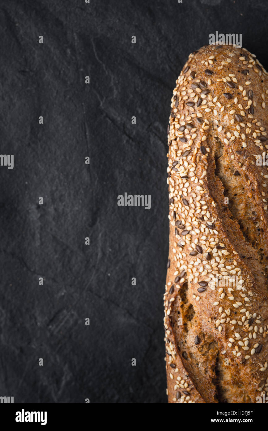 Brot mit Körnern und Samen auf dem dunklen Stein Tisch vertikal Stockfoto