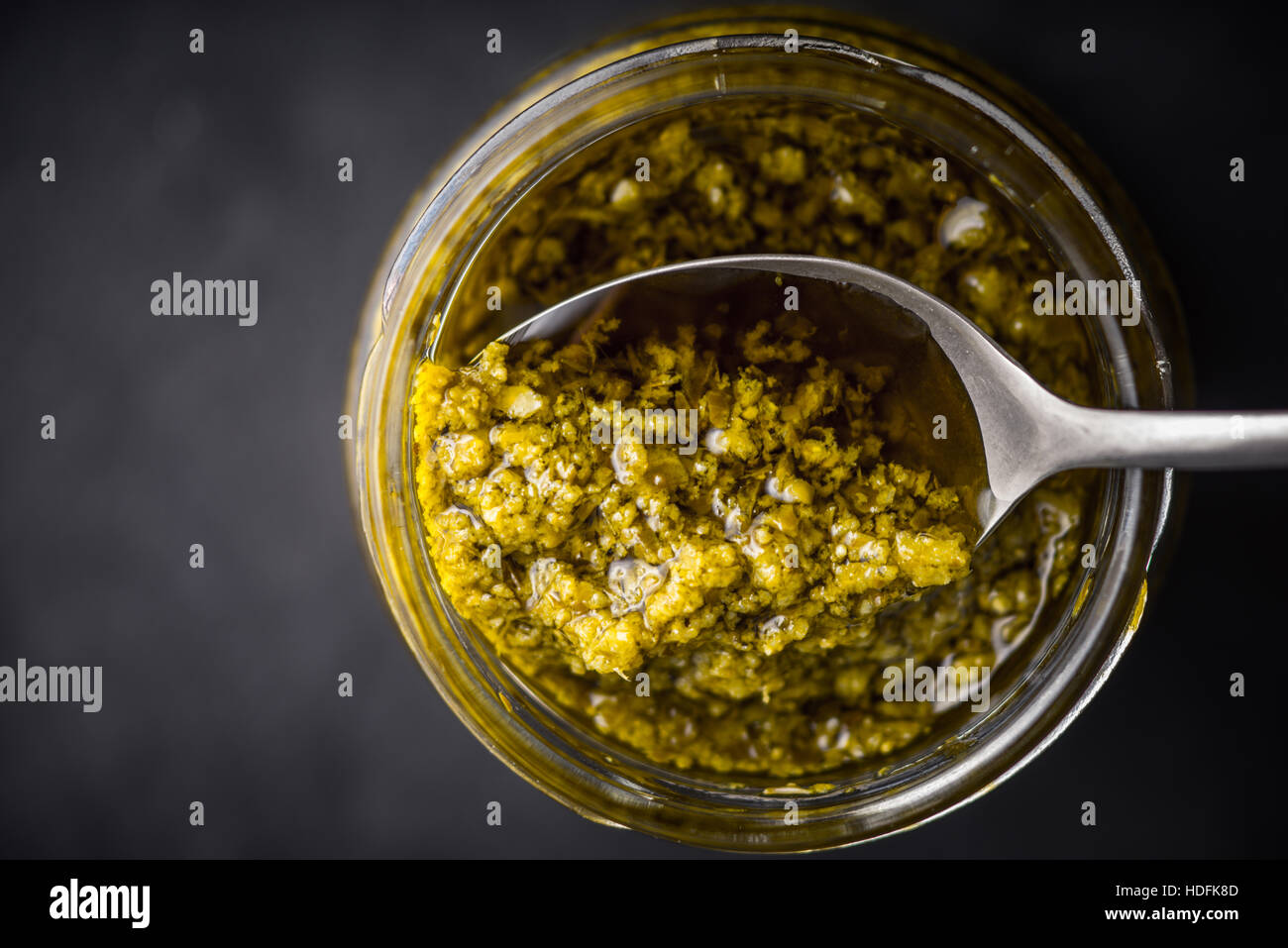 Pesto-Soße in das Glasgefäß mit Löffel Draufsicht Stockfoto