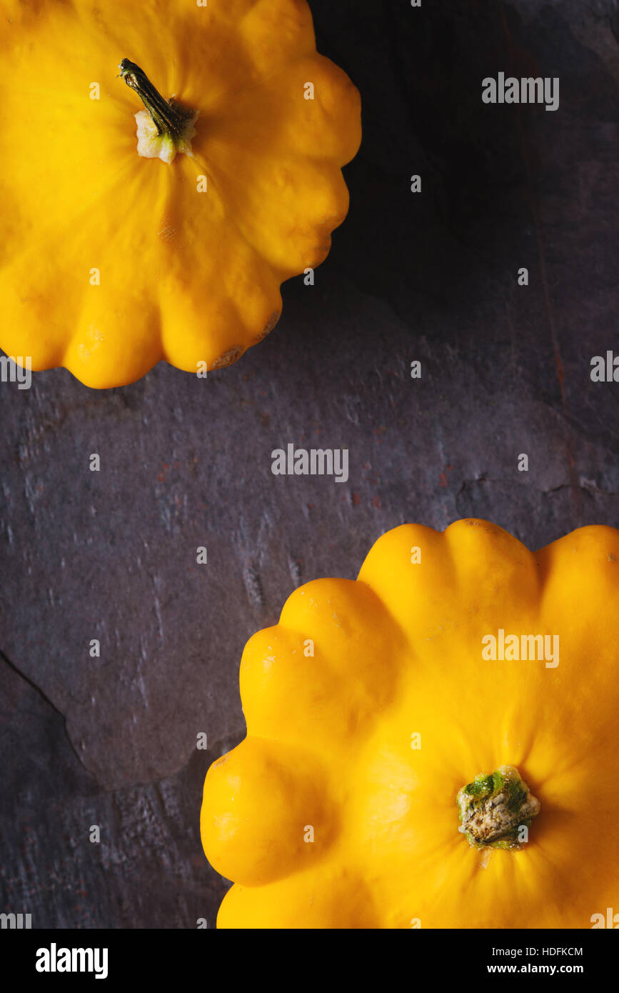 Gelber Kürbis frisch Patty Pan auf dem dunklen Stein Hintergrund vertikale Stockfoto