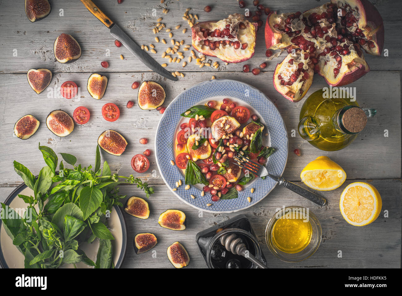 Obstsalat mit Feigen an der Keramikplatte mit Zutaten auf die weißen hölzernen Tischplatte-Ansicht Stockfoto