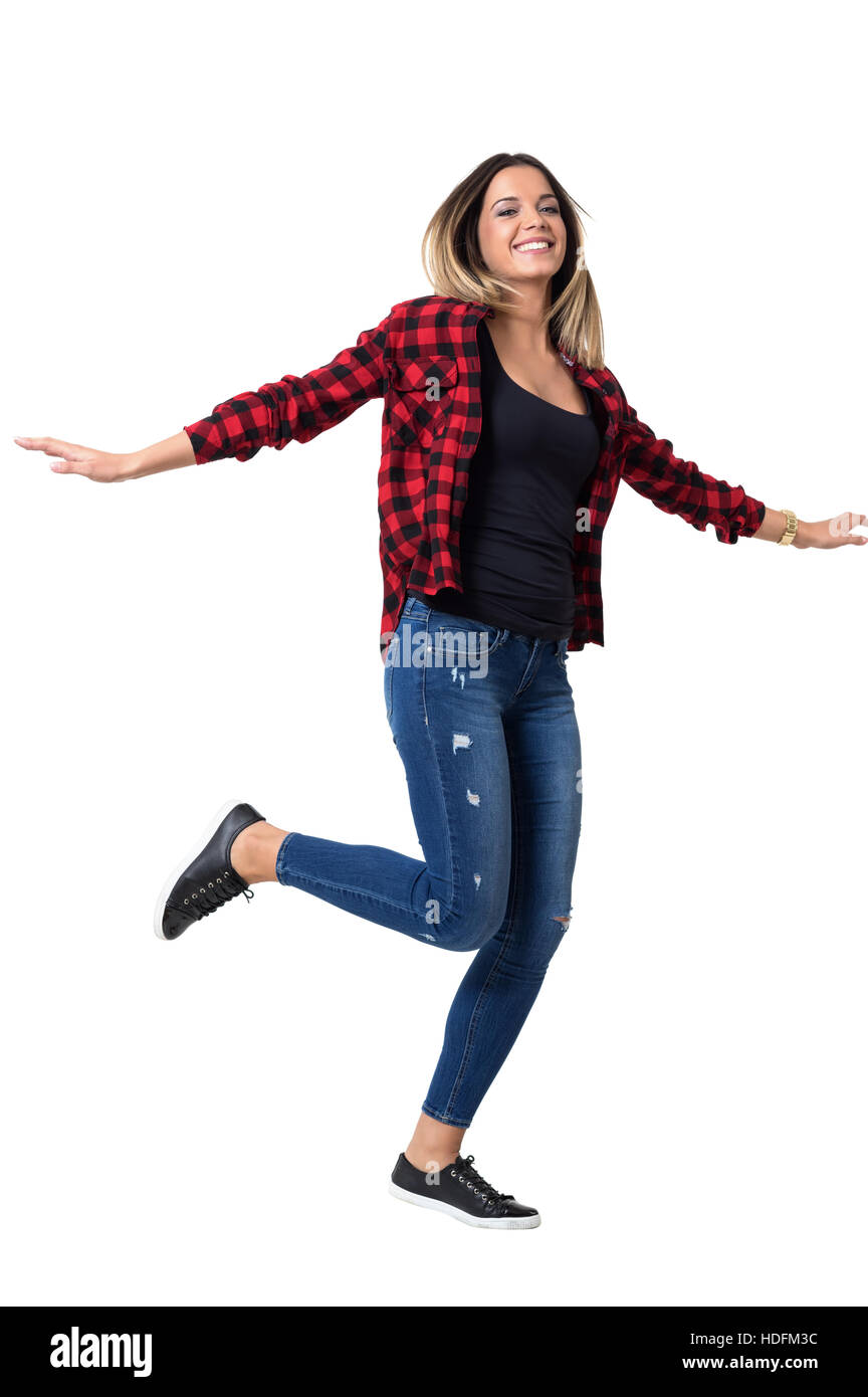 Hübsche junge Frau läuft mit Armen verteilt, trägt Jeans und Rot kariertes Hemd. Ganzkörper-Länge-Porträt isoliert auf weiss Stockfoto
