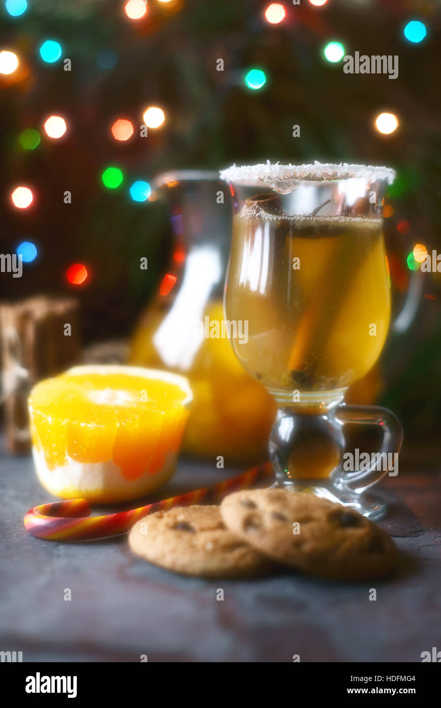 Citrus Punch im Glas auf dem dunklen Tisch mit Weihnachtsschmuck Stockfoto