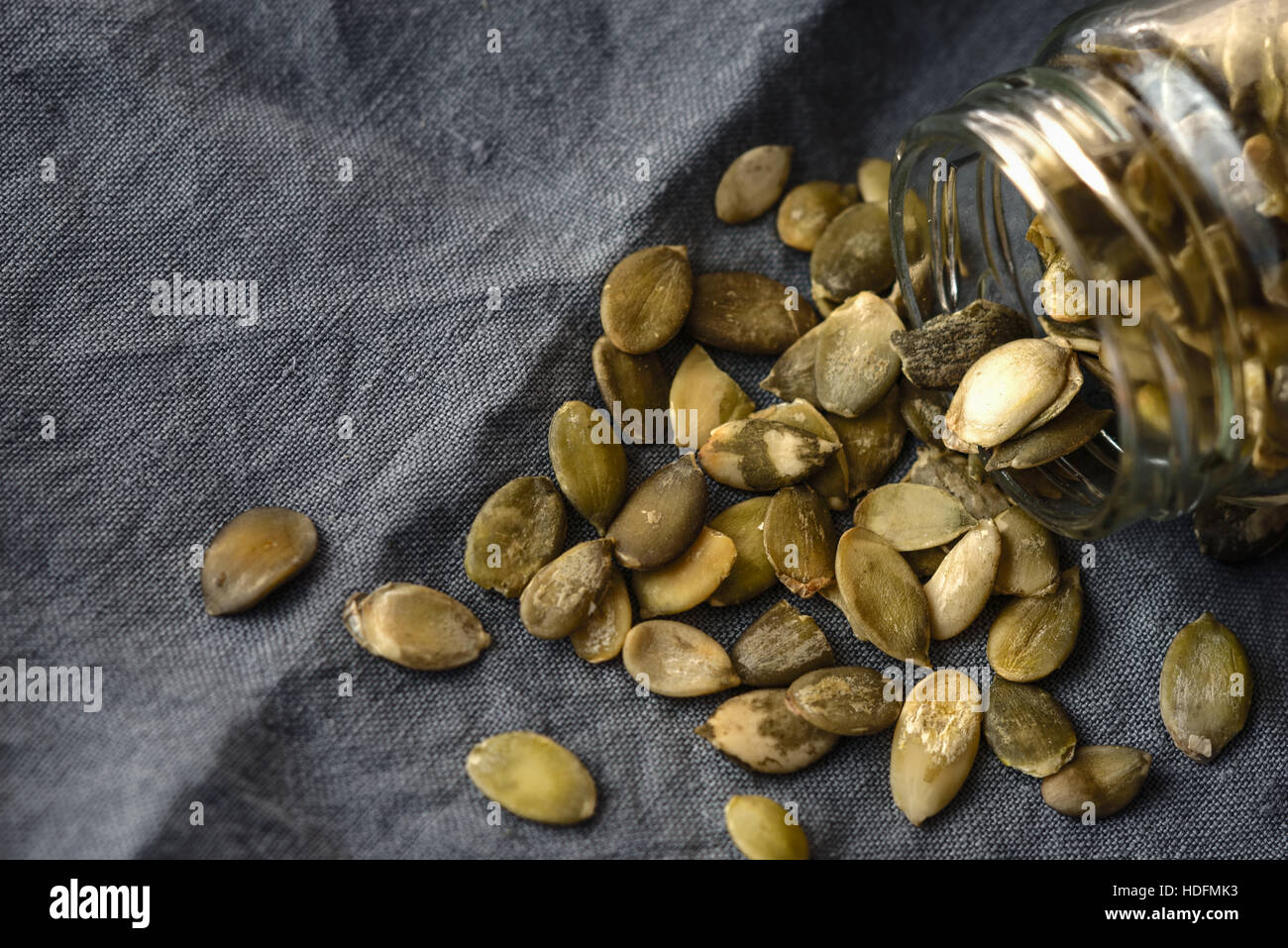 Kürbiskerne in das Glasgefäß auf der grauen Serviette Stockfoto