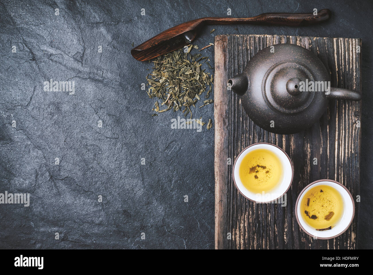 Chinesischen Teekanne und Schüssel mit grünem Tee auf dem Stein Hintergrund Draufsicht Stockfoto