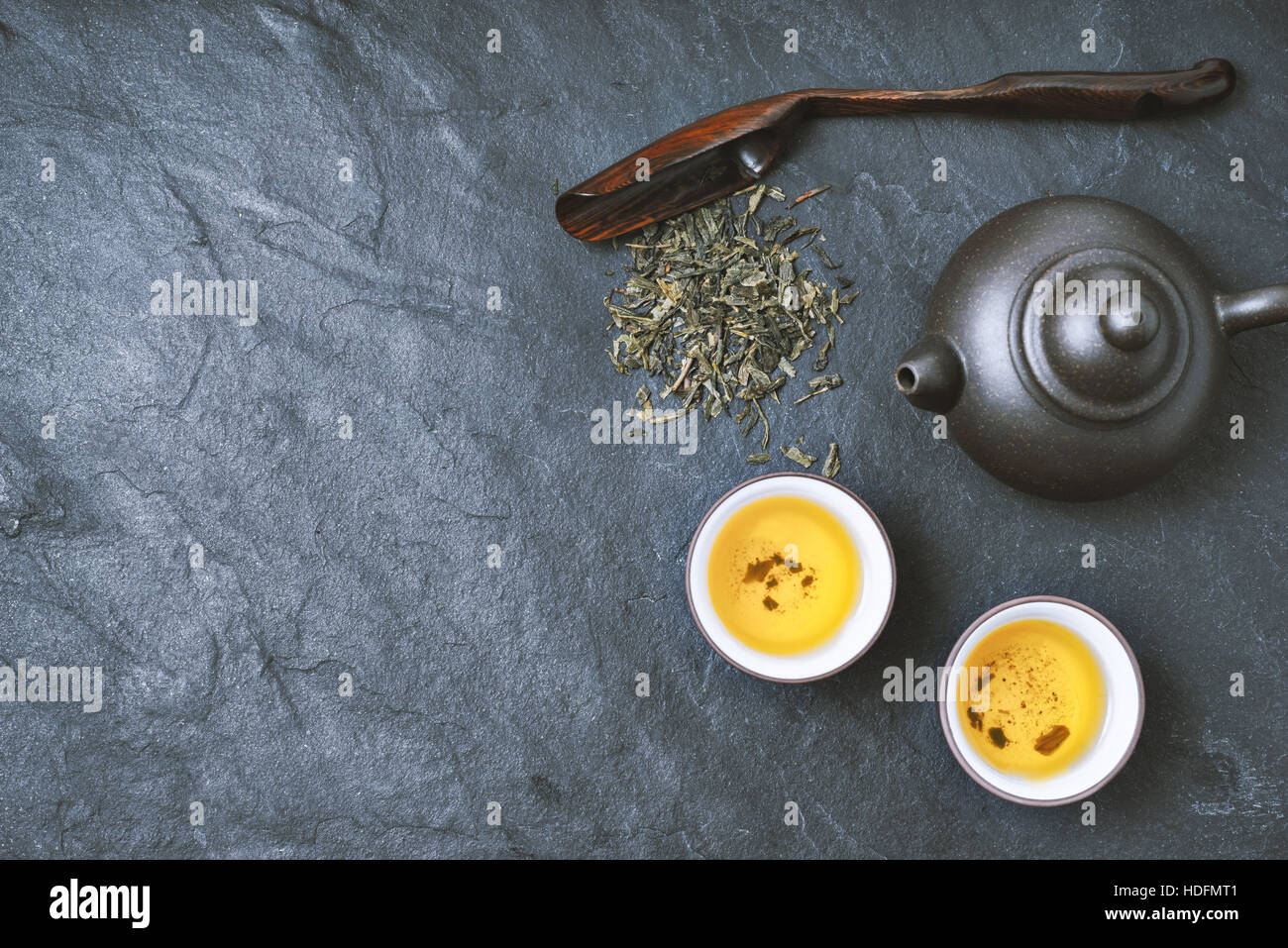 Chinesischen Teekanne und Schüssel mit grünem Tee auf dem Stein Hintergrund horizontale Stockfoto