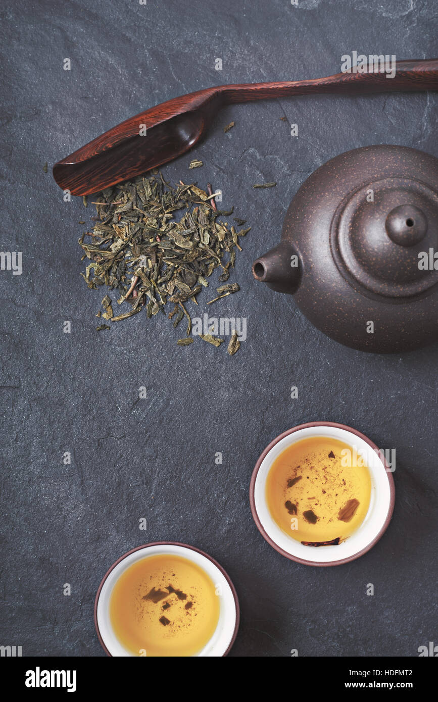 Chinesischen Teekanne und Schüssel mit grünem Tee auf dem Stein Hintergrund vertikale Stockfoto